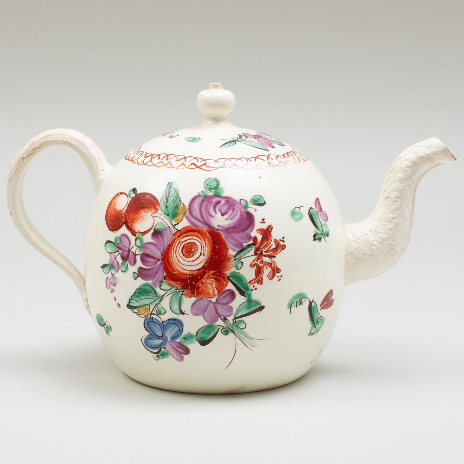Wedgwood Creamware Teapot and Cover: Wedgwood Creamware Teapot and Cover Impressed lowercase mark, painted with colorful flower sprays, set with an entwined strap handle and leaf-molded spout. 8 3/4 in. long. Label for The Kanter Collect