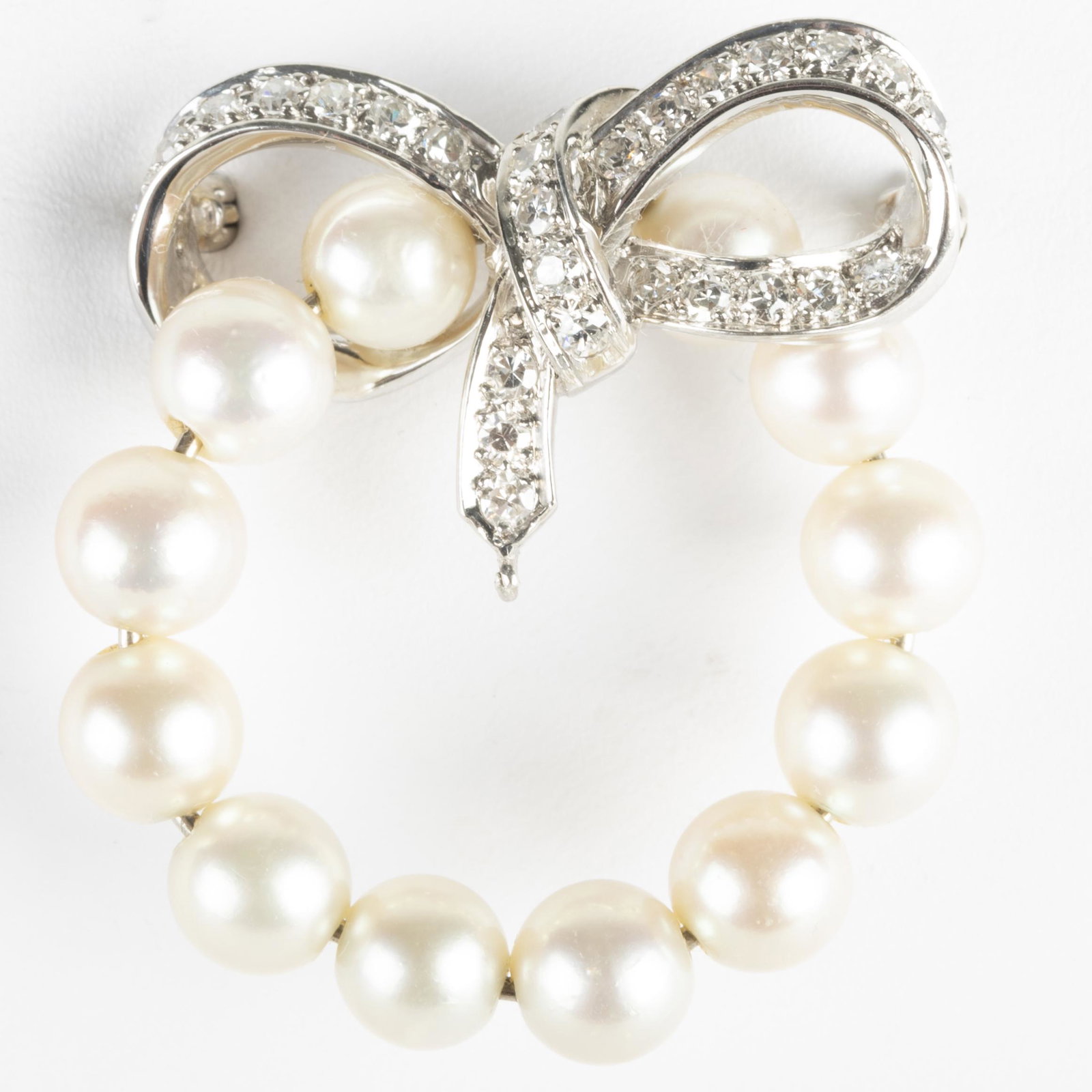 Platinum, Diamond and Cultured Pearl Circle Pin: Platinum, Diamond and Cultured Pearl Circle Pin Set with 0.60 carat of single cut diamonds, pearls measuring 5.8mm. 1 1/4 in. diam., 5.6 dwts. p> Property form the Estate of Mrs. Stanley Krammer, Manh