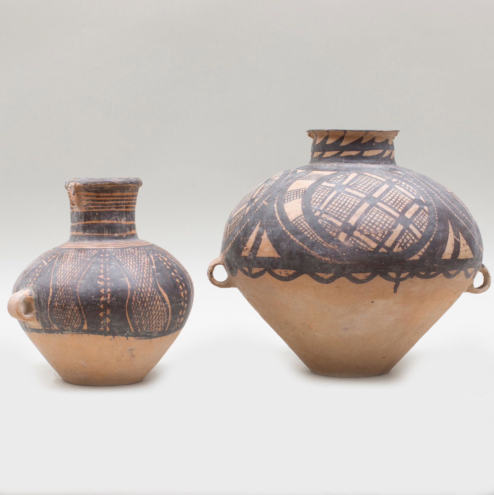Two Chinese Neolithic Painted Pottery Vessels: Two Chinese Neolithic Painted Pottery Vessels Each with handles. Largest:12 x 14 1/2 x 12 in.Â p> Private Collection of Mr. P. Wong, Elegance Gallery, Hong Kong, 1993. Property from a Private Colle
