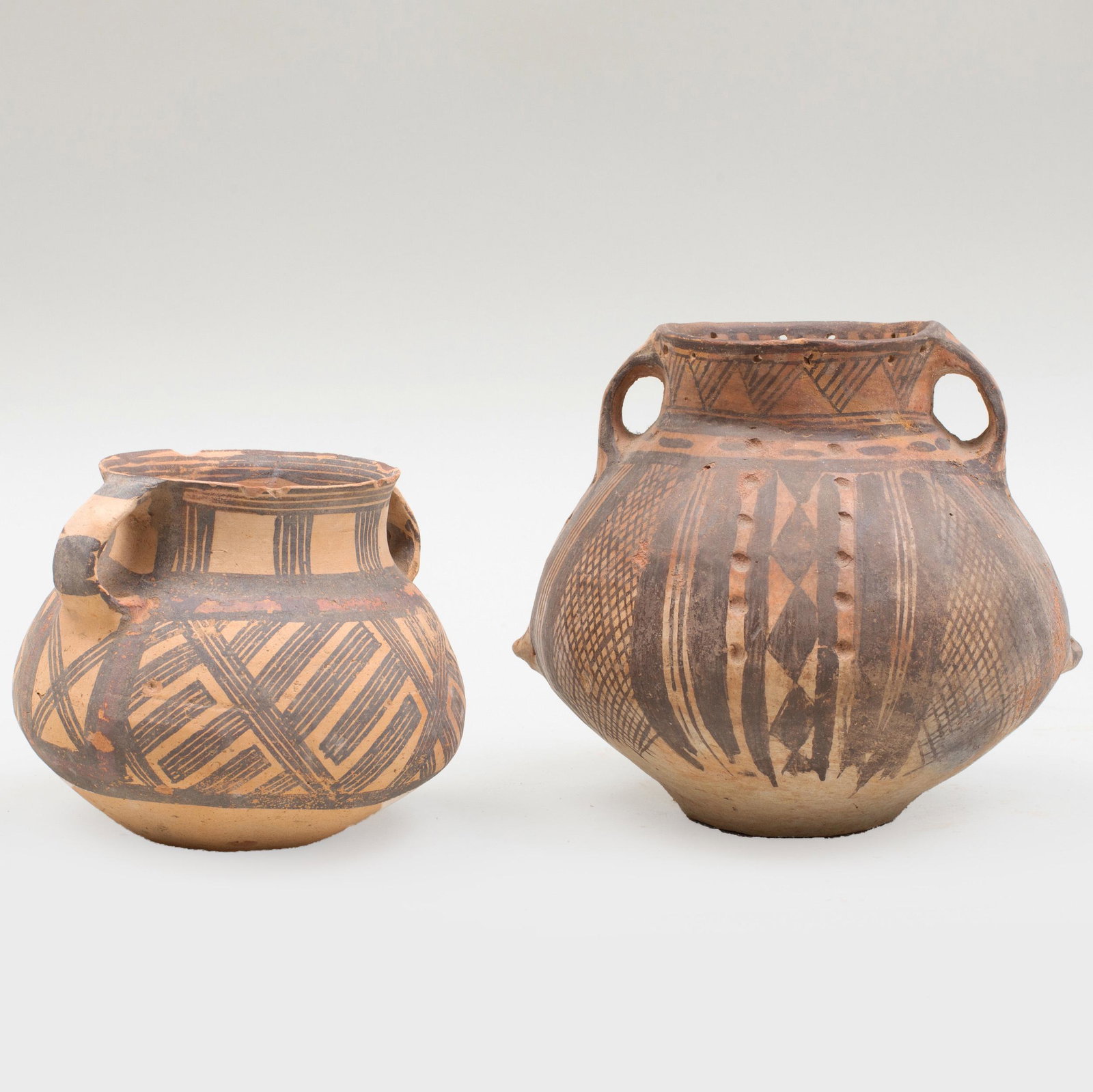 Two Chinese Neolithic Painted Pottery Vessels: Two Chinese Neolithic Painted Pottery Vessels Each with handles, the largest with indented and pierced decoration. Largest: 6 1/4 x 6 1/4 x 6 in. p> Private Collection of Mr. P. Wong, Elegance Gallery