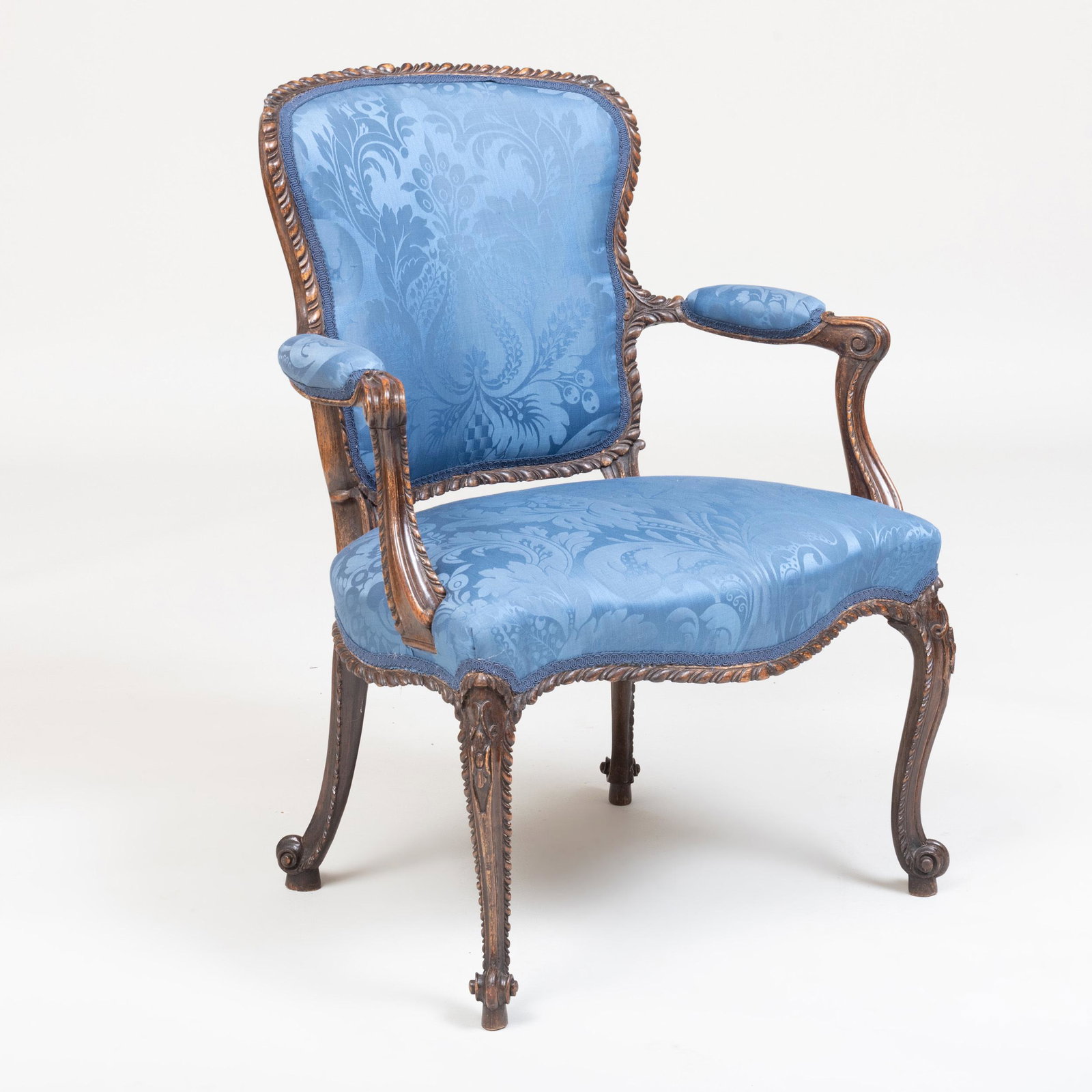 George III Grain Painted Armchair, in the 'French': George III Grain Painted Armchair, in the 'French' Taste Upholstered in blue damask. Fitted with a paper label: Royal School of Needlework, Exhibition Road, S.W. 35 x 26 1/4 x 23 in. Note: The model o