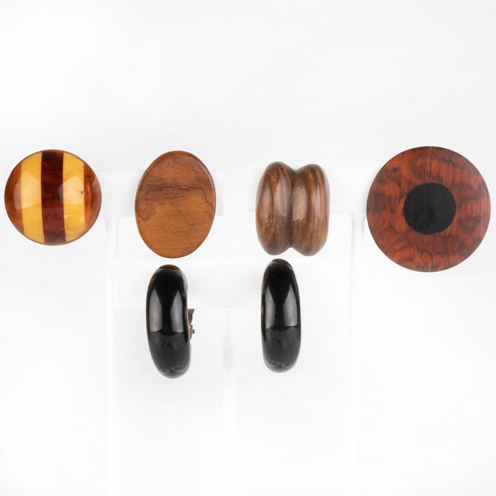 Group of Five Pairs of Earrings: Group of Five Pairs of Earrings Including three pairs of wood earclips, a pair of circular amber earclips and a pair of Monies black hoop earrings. Largest 1 1/2 in. diam.