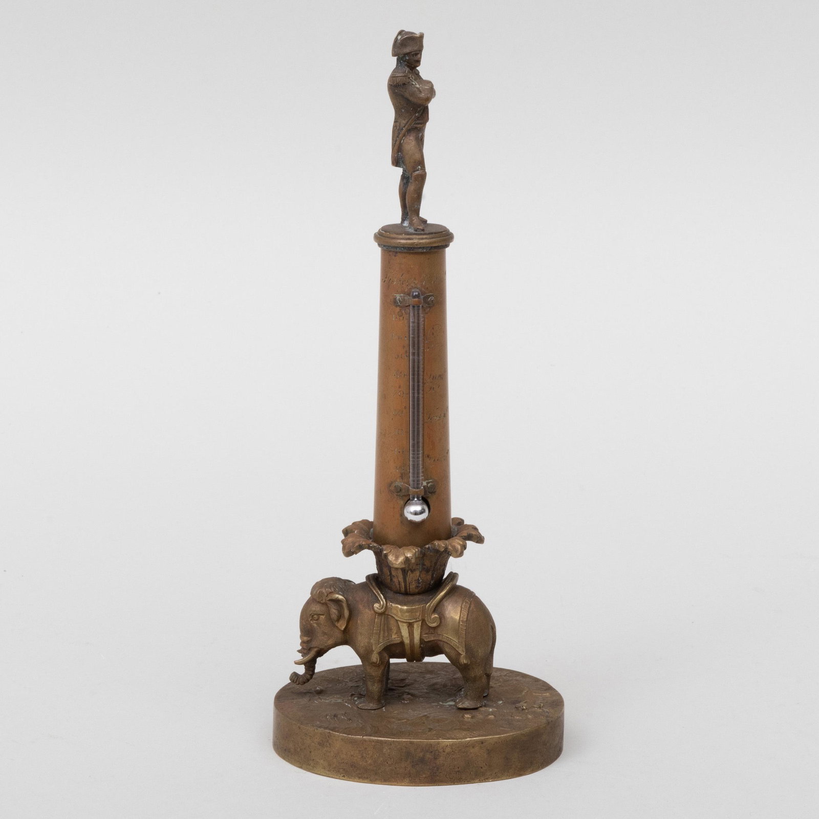 American Brass Columnar Mercury Thermometer with Figure: American Brass Columnar Mercury Thermometer with Figure of Napoleon and an Elephant Signed 'Fisher Philadelphia'. 10 in. high.