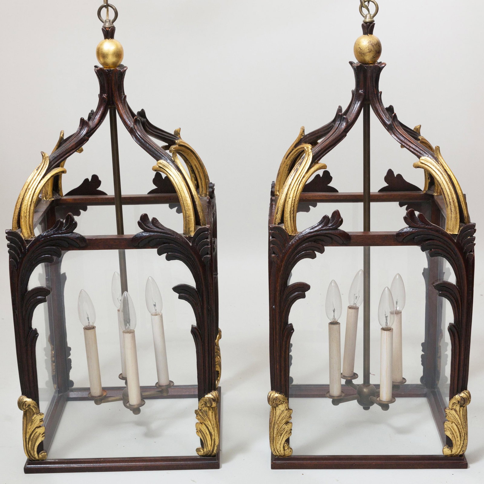 Pair of Neo-Gothic Style Stained Oak and Parcel-Gilt: Pair of Neo-Gothic Style Stained Oak and Parcel-Gilt Hall Lanterns Fitted with four brass lights. 32 x 14 1/4 x 14 1/4 in. Stair & Co., NY.