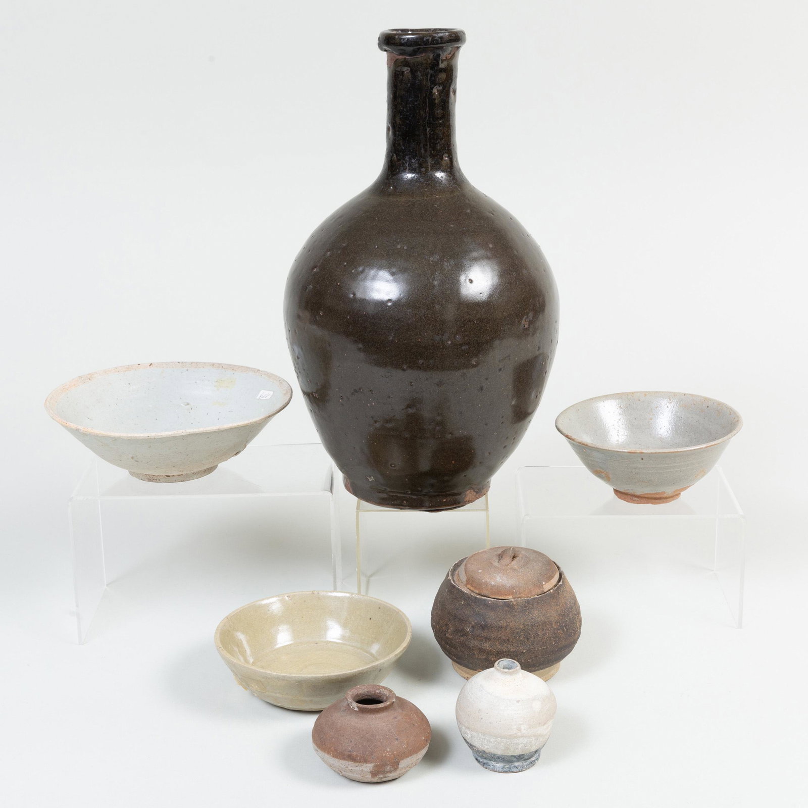 Group of Chinese and Asian Porcelain and Earthenware: Group of Chinese and Asian Porcelain and Earthenware Vessels Comprising: A brown glazed bottle vase Three glazed bowls Two jarlets A jar with associated cover The largest 13 in. high, (7 pcs). P