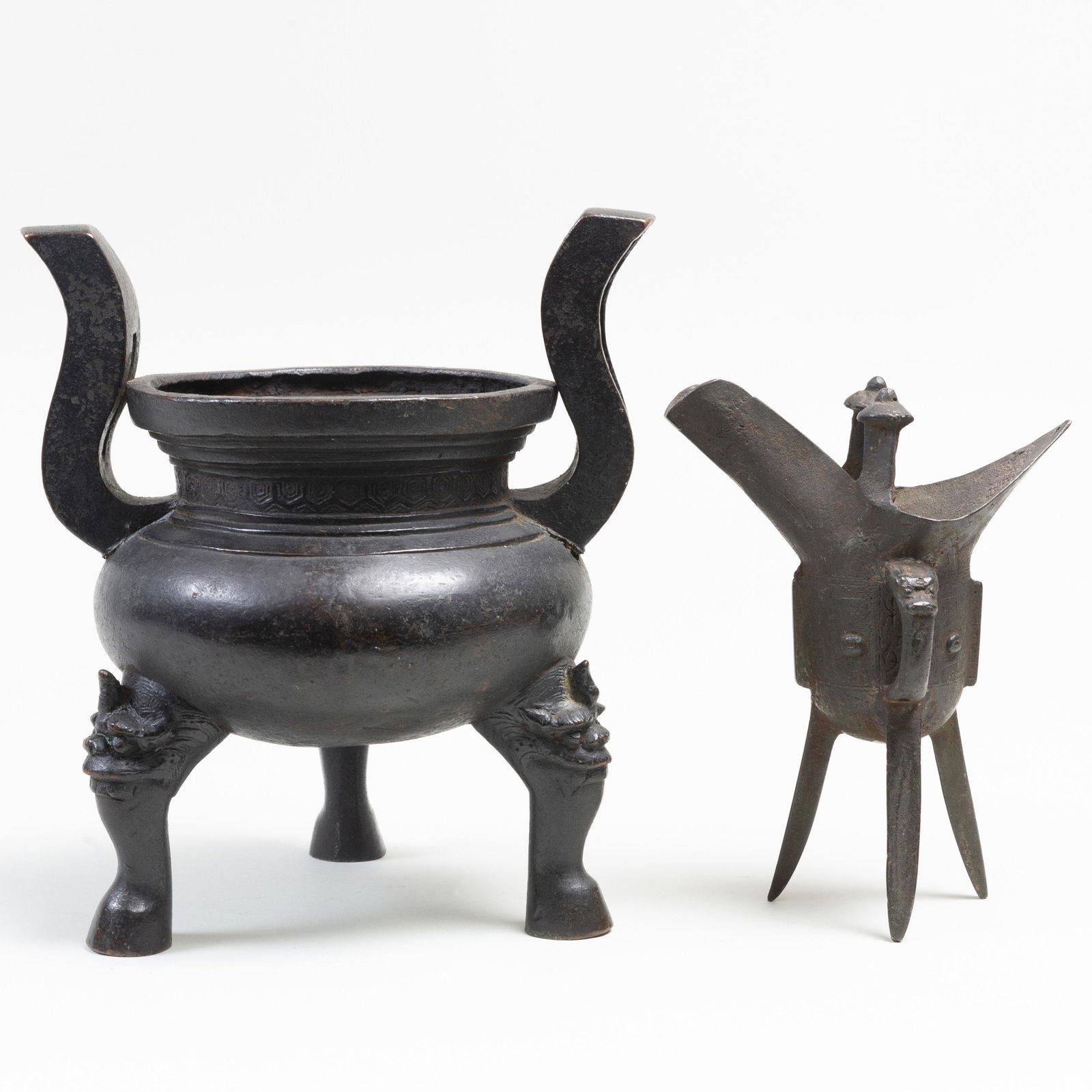 Two Chinese Bronze Archaistic Objects: Two Chinese Bronze Archaistic Objects Comprising a ding and a jue. The larger 9 1/2 in. high.