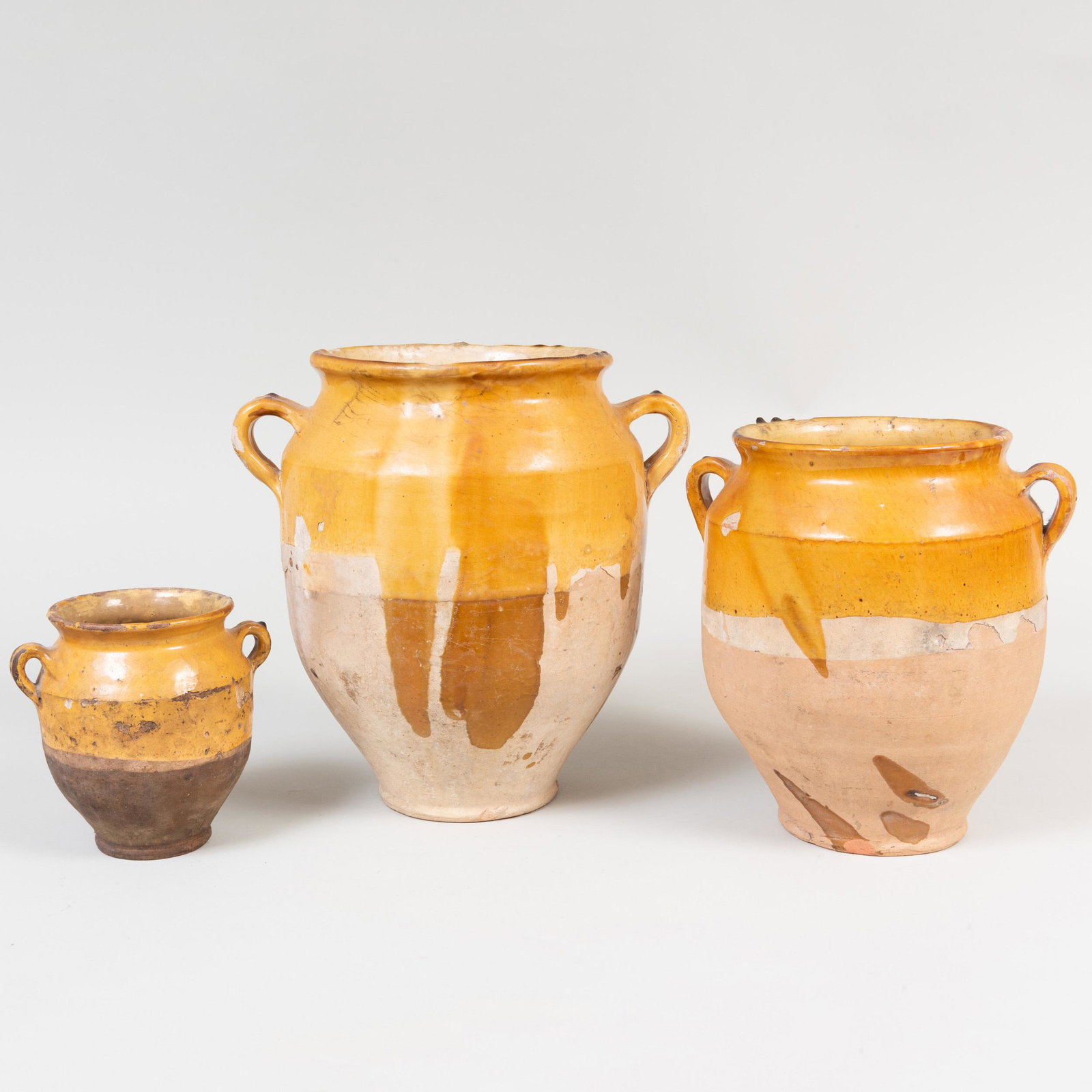 Three French Yellow Glazed Earthenware Crocks: Three French Yellow Glazed Earthenware Crocks The largest 12 3/4 in. high.