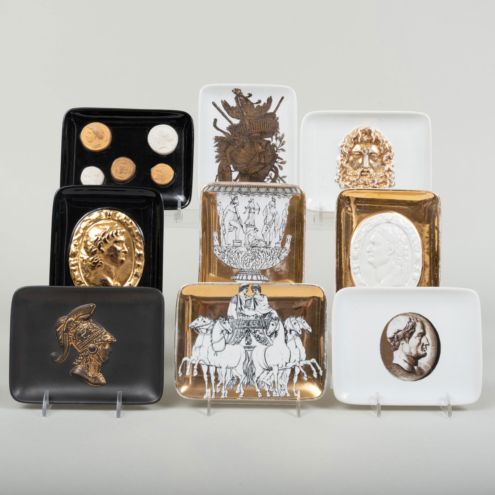 Group of Nine Fornasetti Porcelain Rectangular Dishes: Group of Nine Fornasetti Porcelain Rectangular Dishes Various black printed marks. Comprising: A dish molded with tromp l'oeil coins A gilt-ground dish molded with a portrait medallion