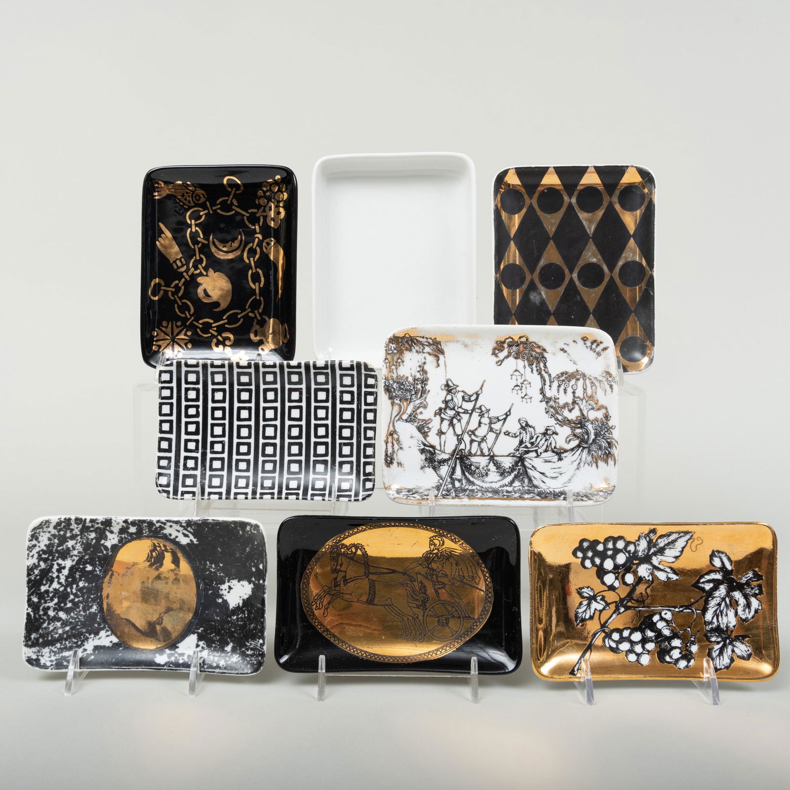Group of Eight Fornasetti Porcelain Rectangular Dishes: Group of Eight Fornasetti Porcelain Rectangular Dishes Black or gilt printed marks. Comprising: A black ground dish printed with gilt-diamond pattern A black ground dish printed with gilt-charm bracel