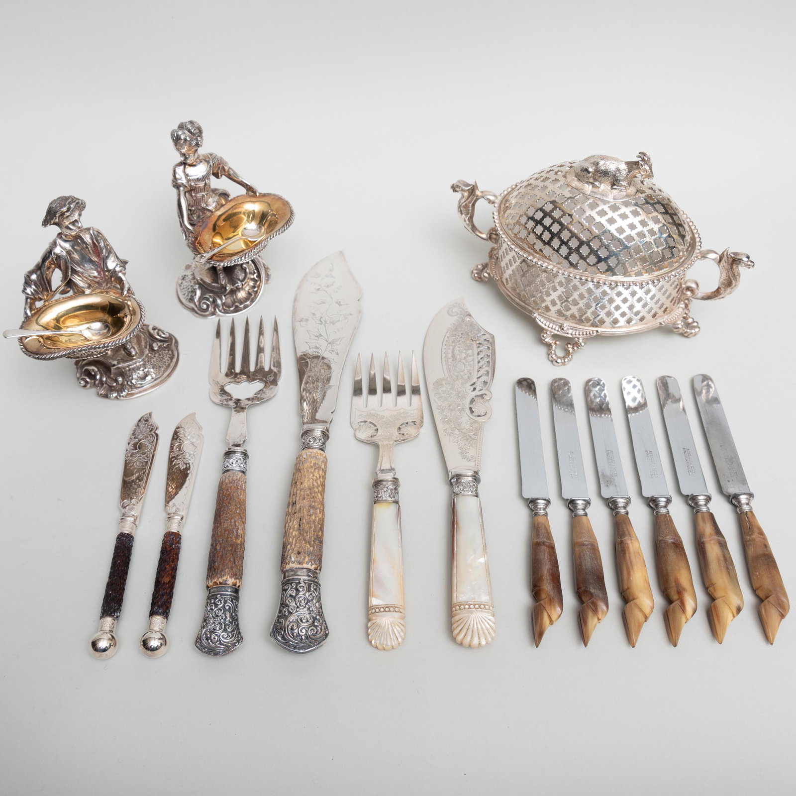 Group of Silver Plate Flatware and Condiment Dishes: Group of Silver Plate Flatware and Condiment Dishes Comprising: A pair of butter spreaders in a fitted case A set of six fruit knives with hoof form horn handles in a fitted case A pair of fish server