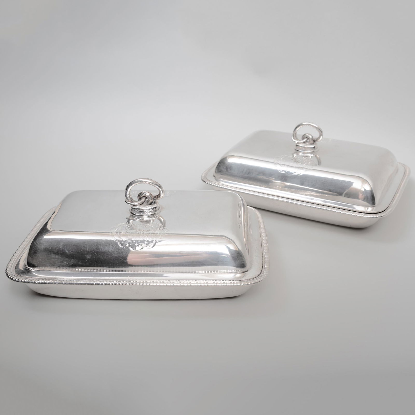 Pair of George III Paul Storr Silver Covered Entrée: Pair of George III Paul Storr Silver Covered Entrée Dishes Maker's mark, London, 1808; each engraved with arms and crests. 11 3/4 in. long, 98 oz. approx. gross weight.