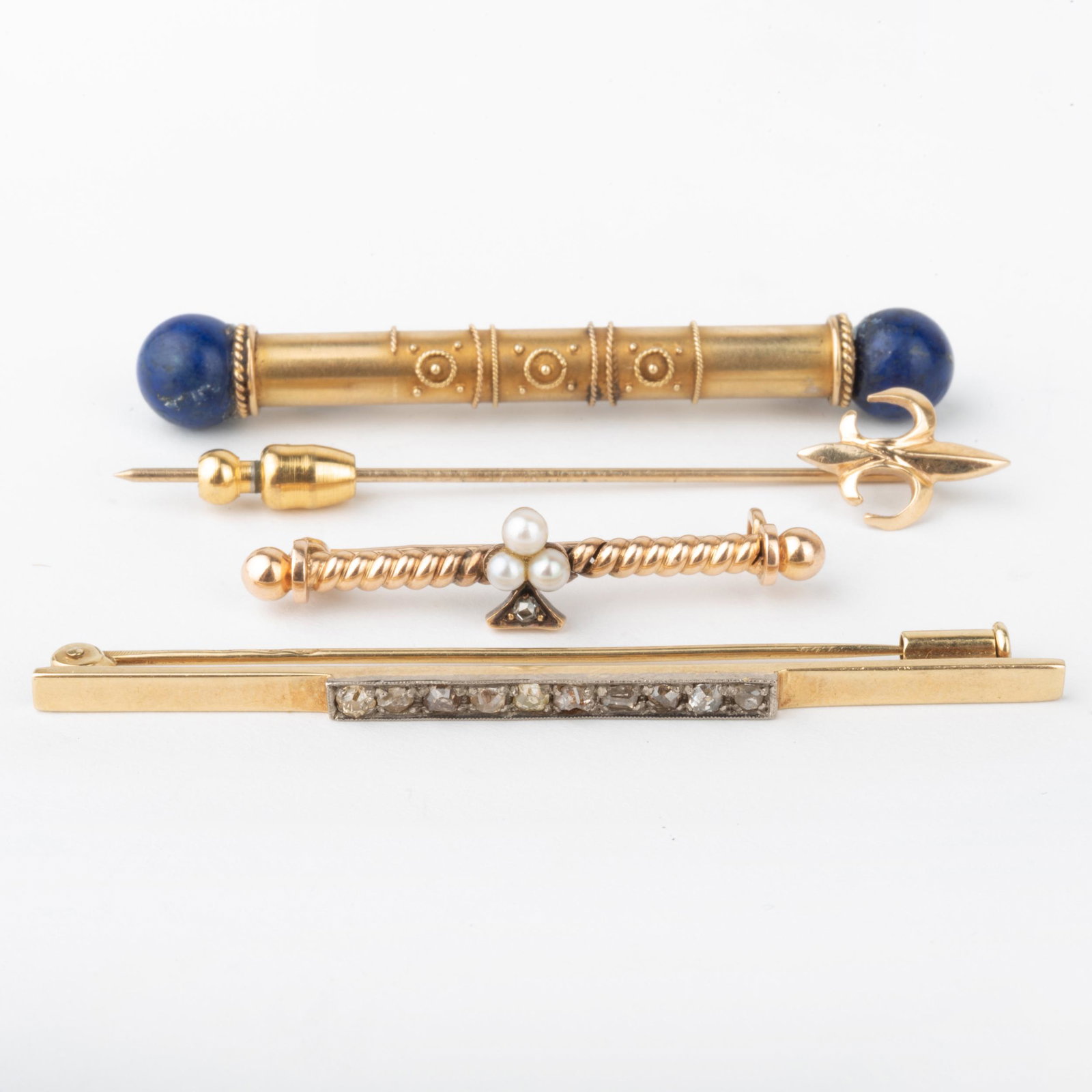 Three Gold Bar Pins and Fleur de Lys Stick Pin: Three Gold Bar Pins and Fleur de Lys Stick Pin One with lapis lazuli stamped '585 / H & S', the second set with diamonds and with hallmarks, the last stamped '14k' and set with seed pearls and a diamo
