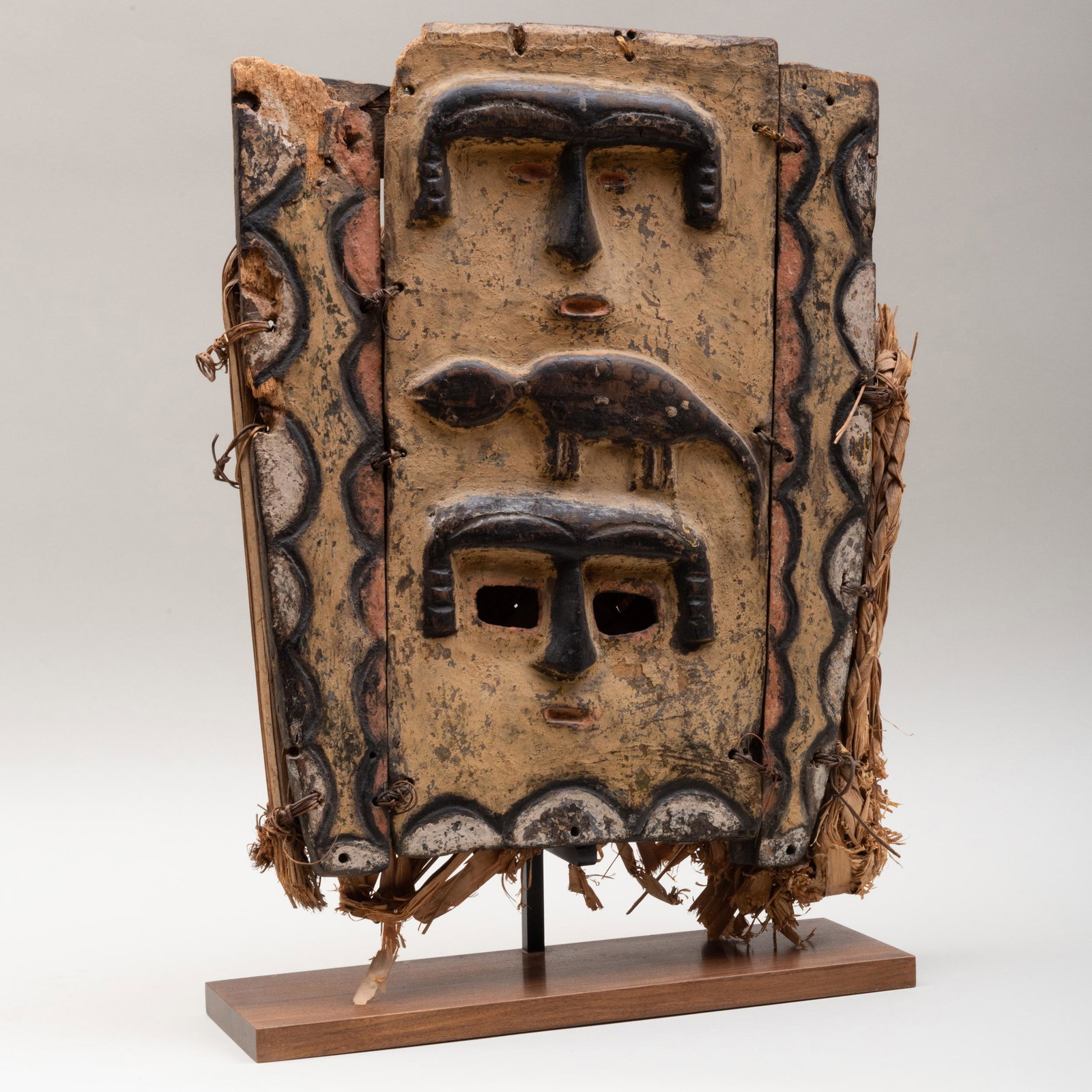 Nigerian Painted Wood and Raffia Plank Mask, Ibibio: Nigerian Painted Wood and Raffia Plank Mask, Ibibio Eket Raised on stand. 22 3/4 x 17 x 2 3/4 in. (overall). Allan Stone Gallery, New York, 1990.