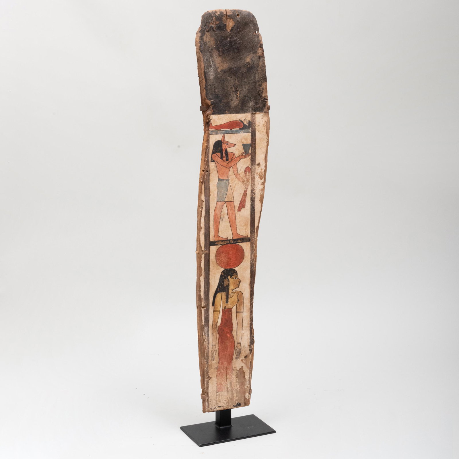 Egyptian Painted Wood Sarcophagus Panel with Anubis and: Egyptian Painted Wood Sarcophagus Panel with Anubis and Isis with The Deceased Mounted on black steel armature with lucite cover, together with a limestone base with a humidity gauge. 5 ft. 7 in. x 28