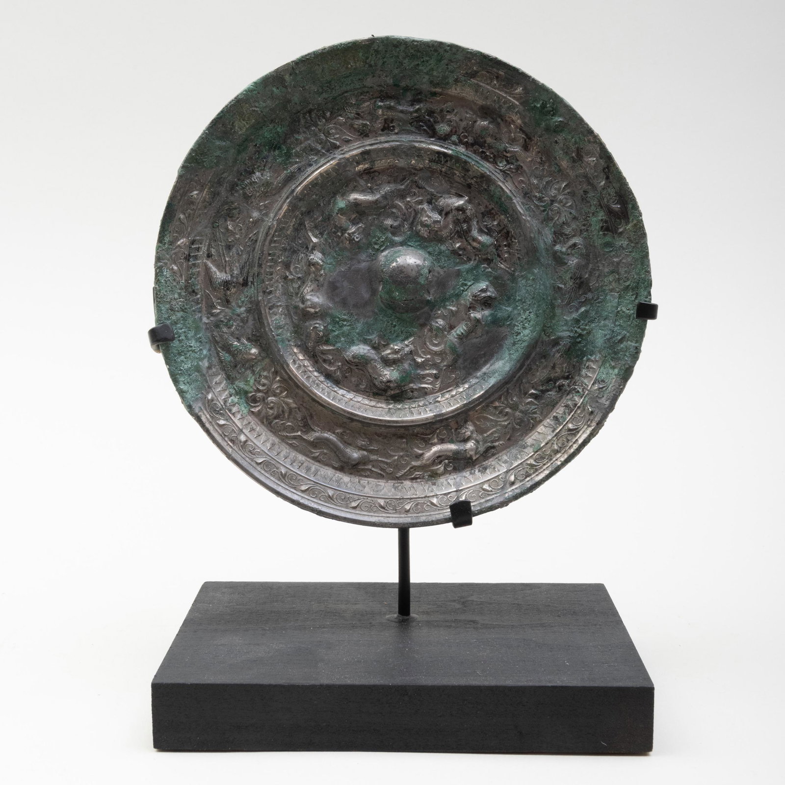 Chinese Silvered Bronze Mirror: Chinese Silvered Bronze Mirror Decorated with beasts chasing each other's tails around the central knob, raised on stand. The mirror 5 in. diam. Property from the Collection of Tom Swope, Hudson, NY M
