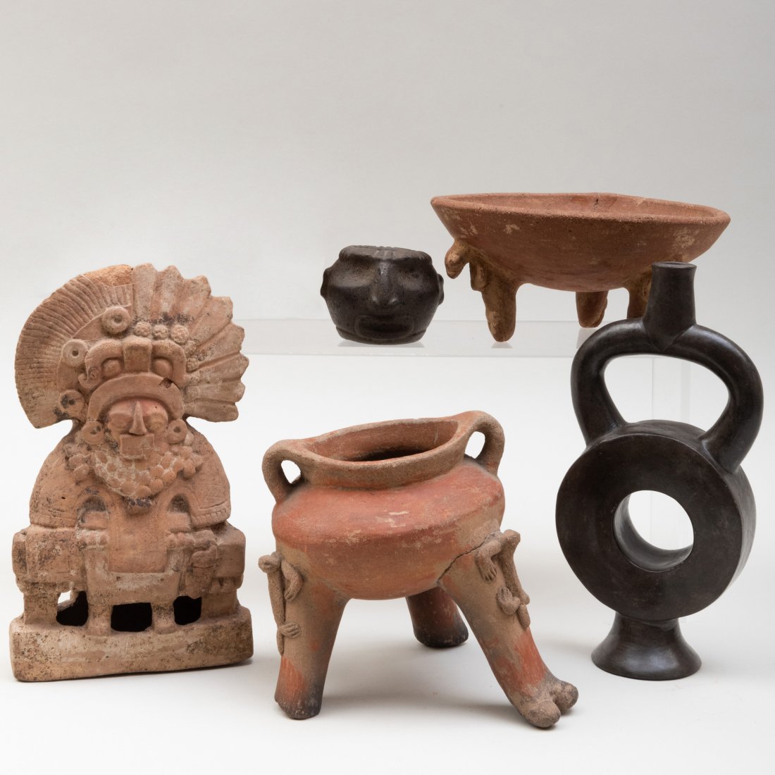 Group of Pre-Columbian Pottery Artifacts: Group of Pre-Columbian Pottery ArtifactsComprising:A Mayan or Zapotec figure, MexicoA Peruvian black stirrup cup A Meso-American tripod bowlA Costa Rican tripod vesselA stone figural ringThe largest 8