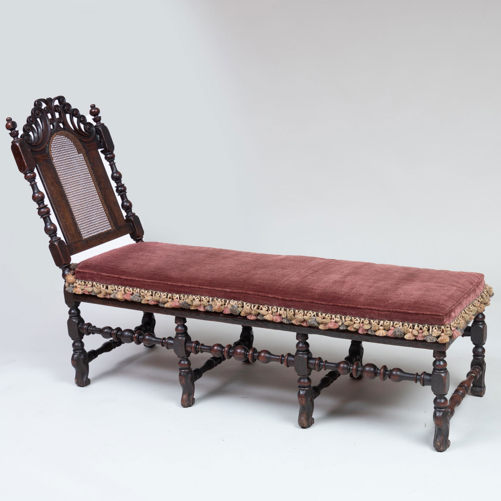William and Mary Turned and Carved Walnut and Caned: William and Mary Turned and Carved Walnut and Caned Chaise Lounge Formerly reclined, now bolted, fitted with a tasseled cushion, composed of later elements. 43 3/4 x 5 ft. 3 in. x 21 in. Collection of