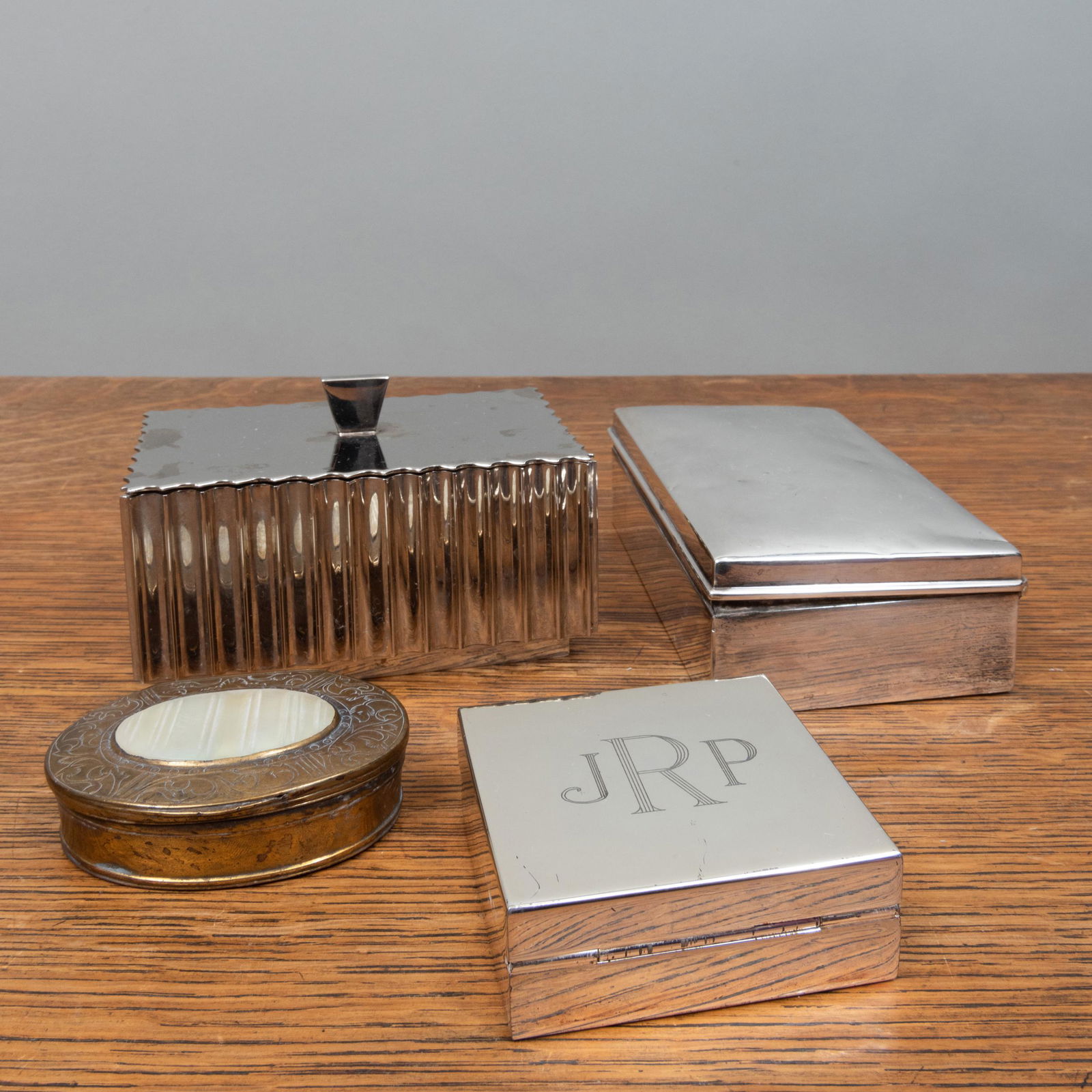 TIffany & Co. Silver Cigarette Box and a Group of: TIffany & Co. Silver Cigarette Box and a Group of Vessels The Tiffany marked 'Sterling', with wood liner. The vessels comprising: A lobed silver metal box and cover A silver metal travel clock, monogr