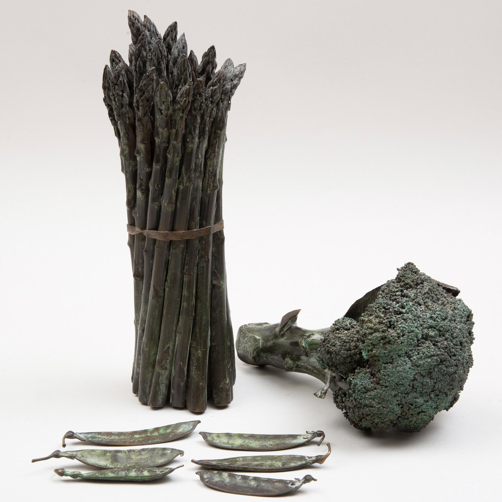 Group of Bronze Models of Vegetables by Donald L. Reed: Group of Bronze Models of Vegetables by Donald L. Reed Signed. Comprising: A head of broccoli A bunch of asparagus Six peapods The asparagus 11 3/4 x 3 1/2 in. diam., (8 pcs). Selected Property