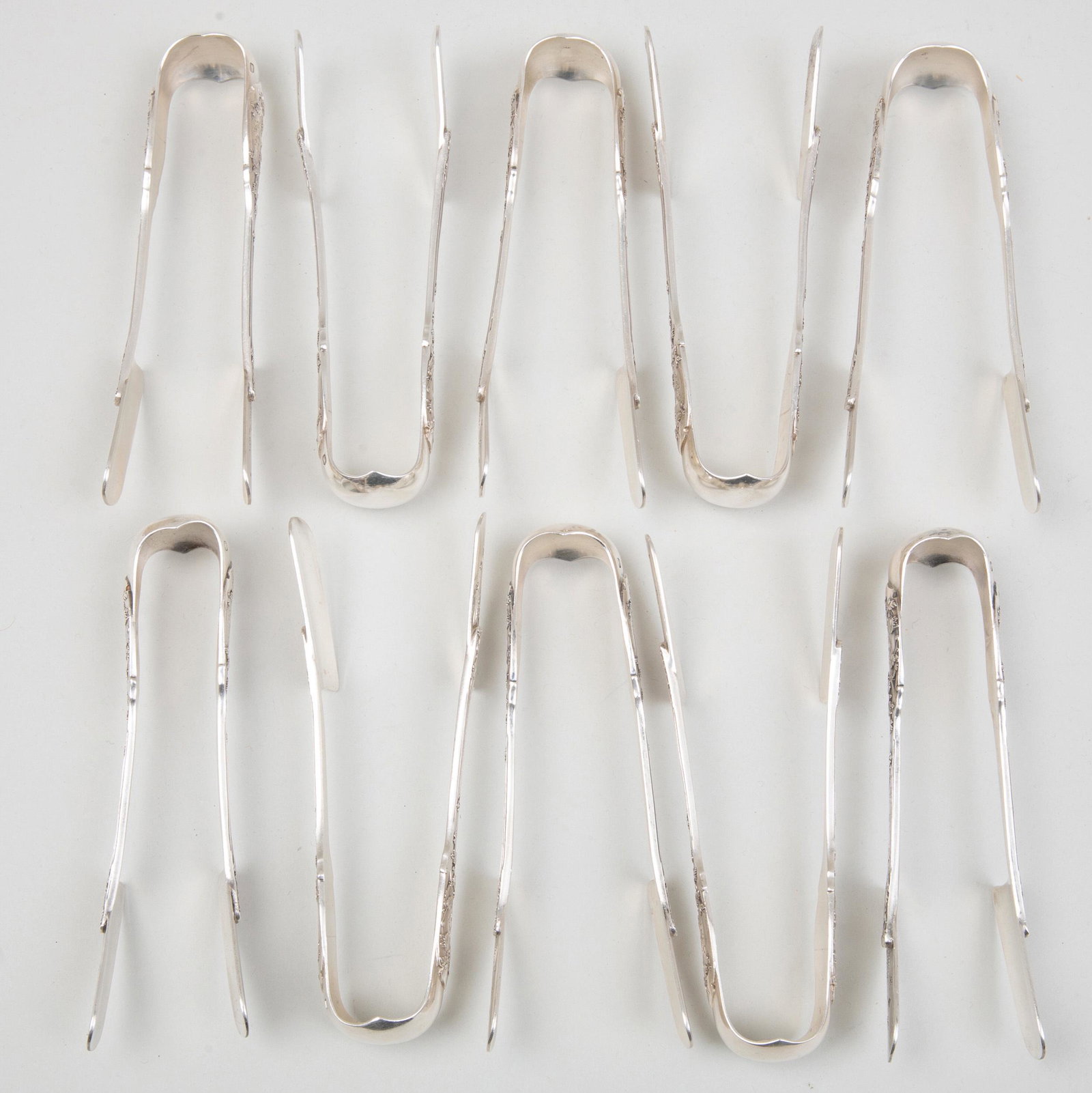 Set of Eleven Puiforcat Silver Sugar Tongs: Set of Eleven Puiforcat Silver Sugar Tongs Marked '.950', monogrammed. 5 1/4 in. long, 18.2 oz. approx. weight. Selected Property from the Collection of Mr. and Mrs. Gutfreund