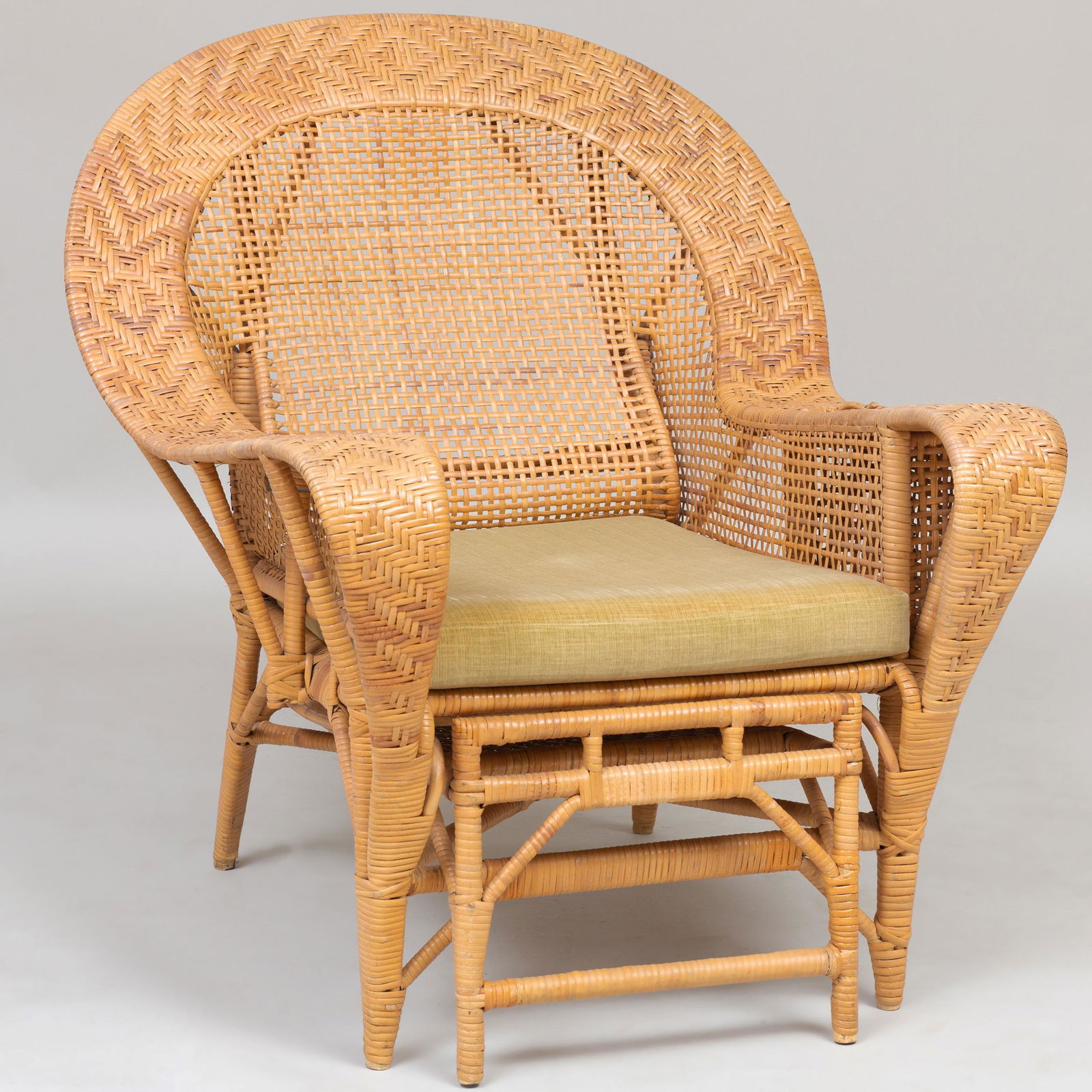 Large Wicker Arm Chair with Retractable Footrest: Large Wicker Arm Chair with Retractable Footrest The armrests fitted with a covered compartment and a bottle coaster. Fitted with an upholstered cushion. 37 1/2 x 29 x 33 1/2 in. Selected Property fro