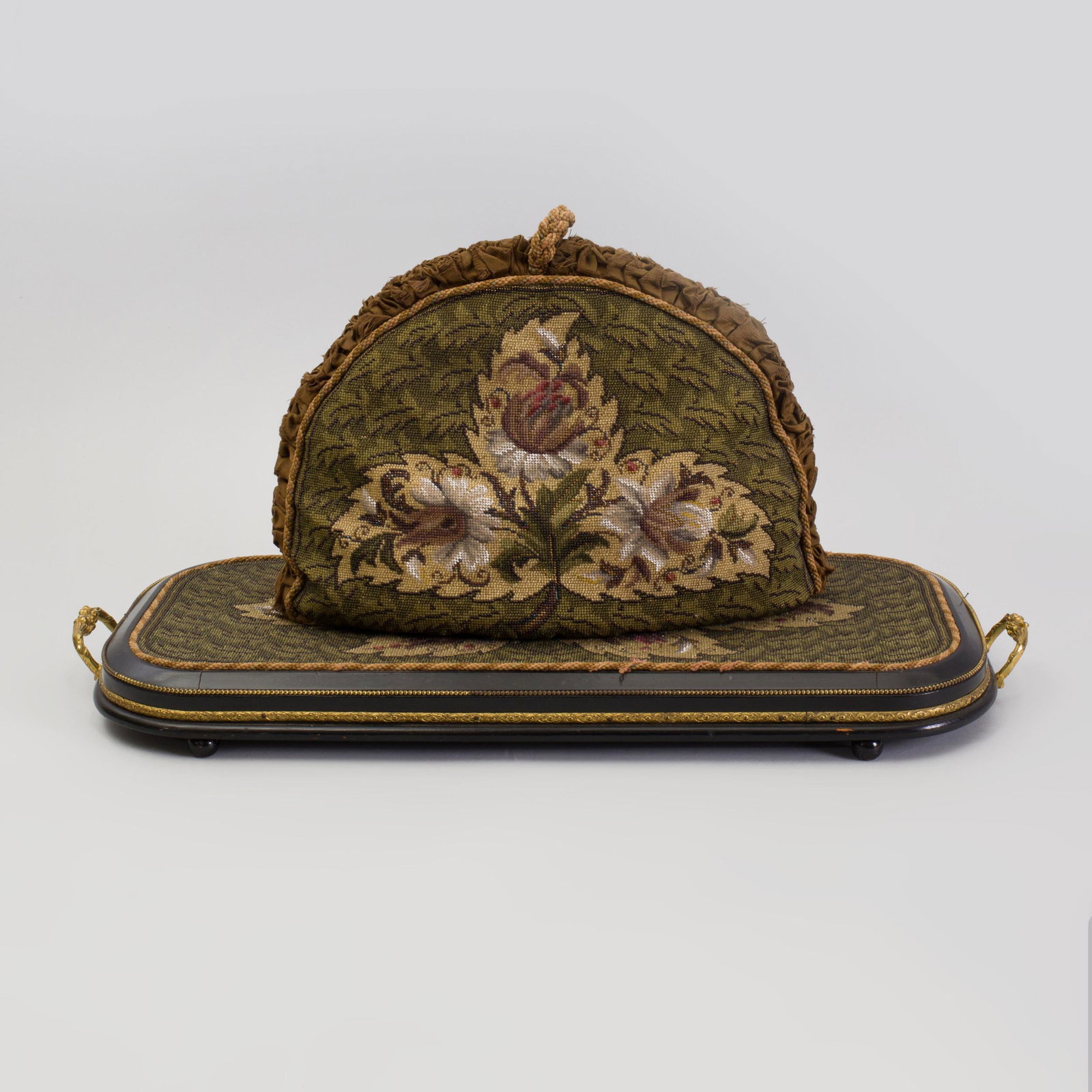 Victorian Beadwork Mounted Ebonized Wood Tray and a: Victorian Beadwork Mounted Ebonized Wood Tray and a Beadwork Tea Cozy The tray with gilt-metal handles and beaded and floral bands. 27 1/4 x 12 x 2 1/4 in. and 12 x 16 1/4 in. Selected Property from t