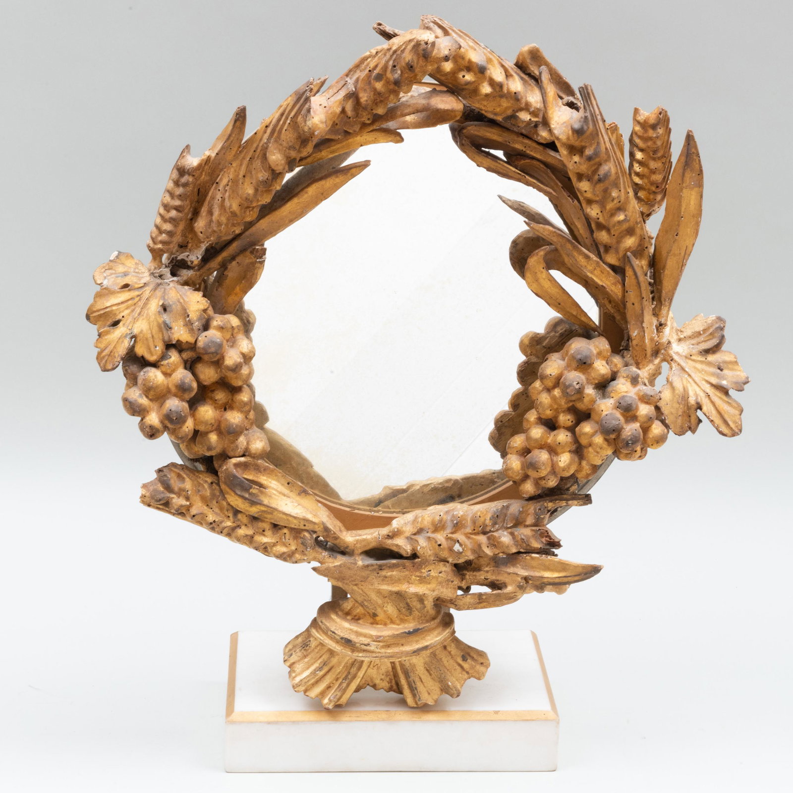 Looking Glass Mounted with Baroque Style Giltwood: Looking Glass Mounted with Baroque Style Giltwood Wreath 22 x 19 x 7 in. (overall). Property from the Estate of Jan Cowles