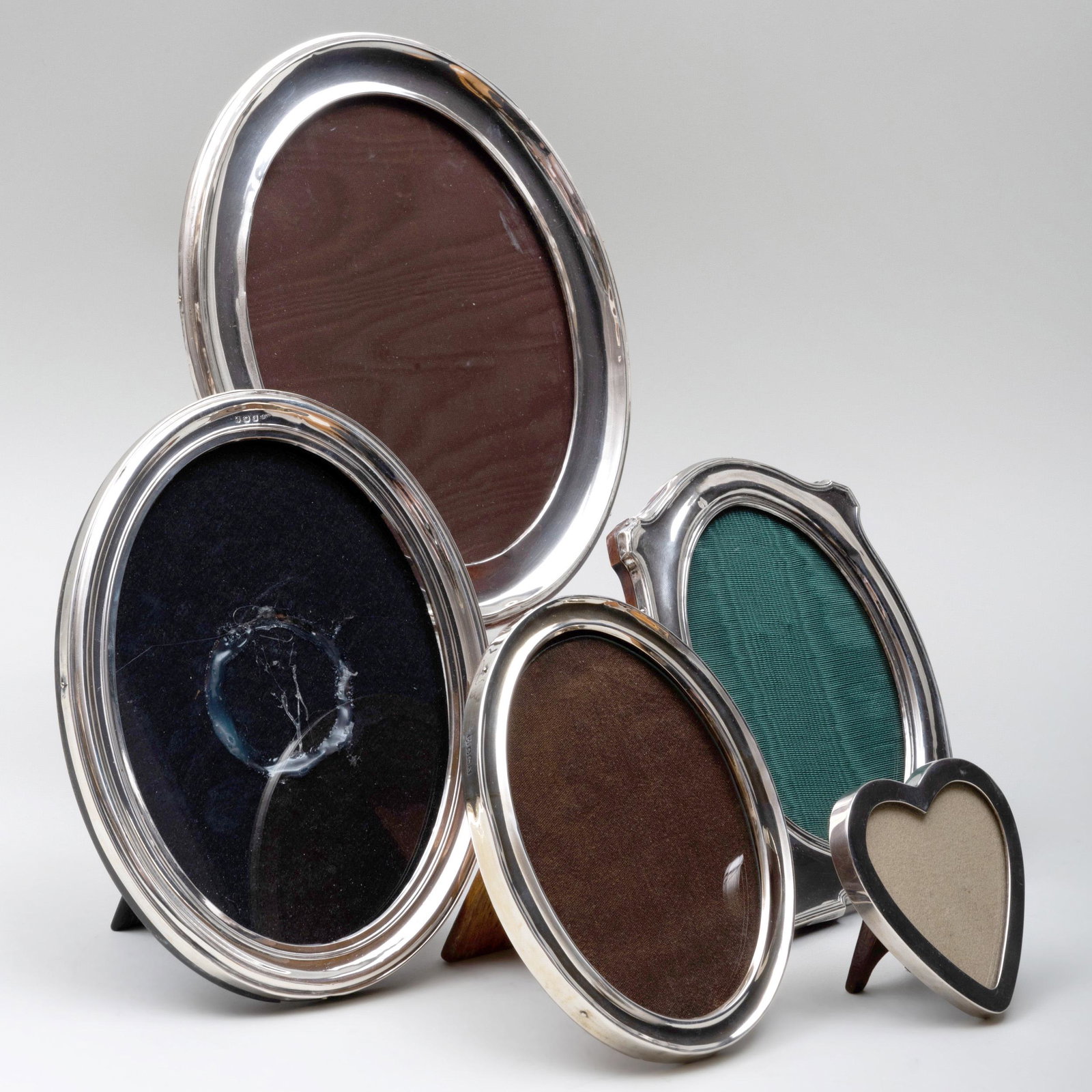 Five Silver Picture Frames: Five Silver Picture Frames Comprising: A small heart shaped frame, marked 'Sterling' and '.925' A small oval frame, mark of William Neale & Son, Birmingham, 1922 An oval frame, marked Birmingham, make