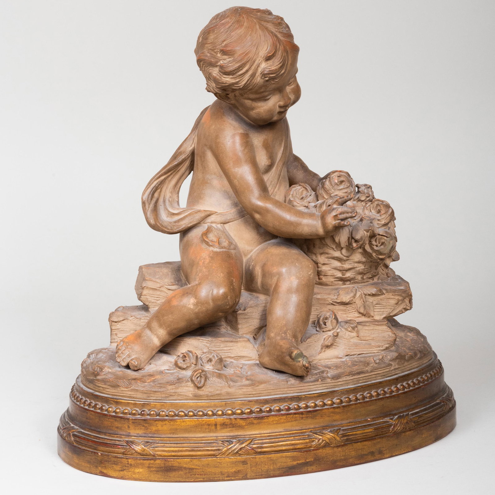 French Terracotta Putti with a Flower Basket: French Terracotta Putti with a Flower Basket Indistinctly signed. 17 12 x 16 x 9 in. Property from the Collection of Ambassador and Mrs. Felix Rohatyn