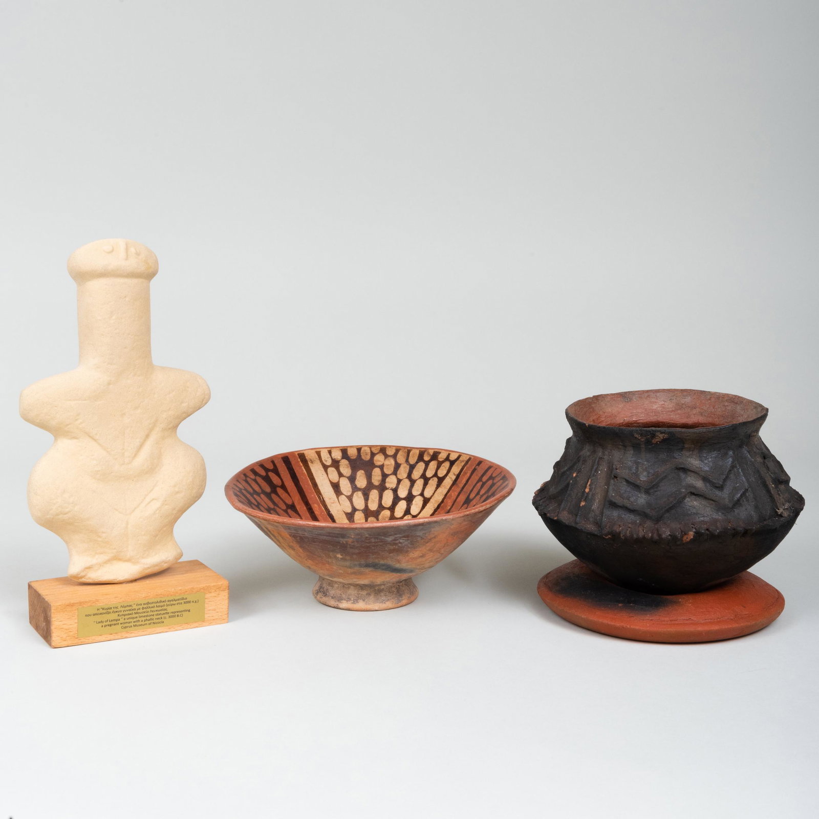 Group of Pottery Wares: Group of Pottery Wares Comprising: A bowl with geometric design A wood fired pottery vessel and ring form stand A copy of the 'Lady of Lempa' on wood stand The largest 10 1/2 in. high. The bowl Joan B
