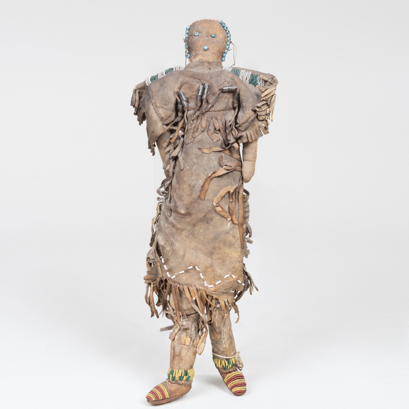 Plains Beaded and Hide Doll: Plains Beaded and Hide Doll Fitted with a typed inventory number 2203 on her skirt. 15 1/4 in. tall. Property from the Estate of Martin and Faith-Dorian Wright