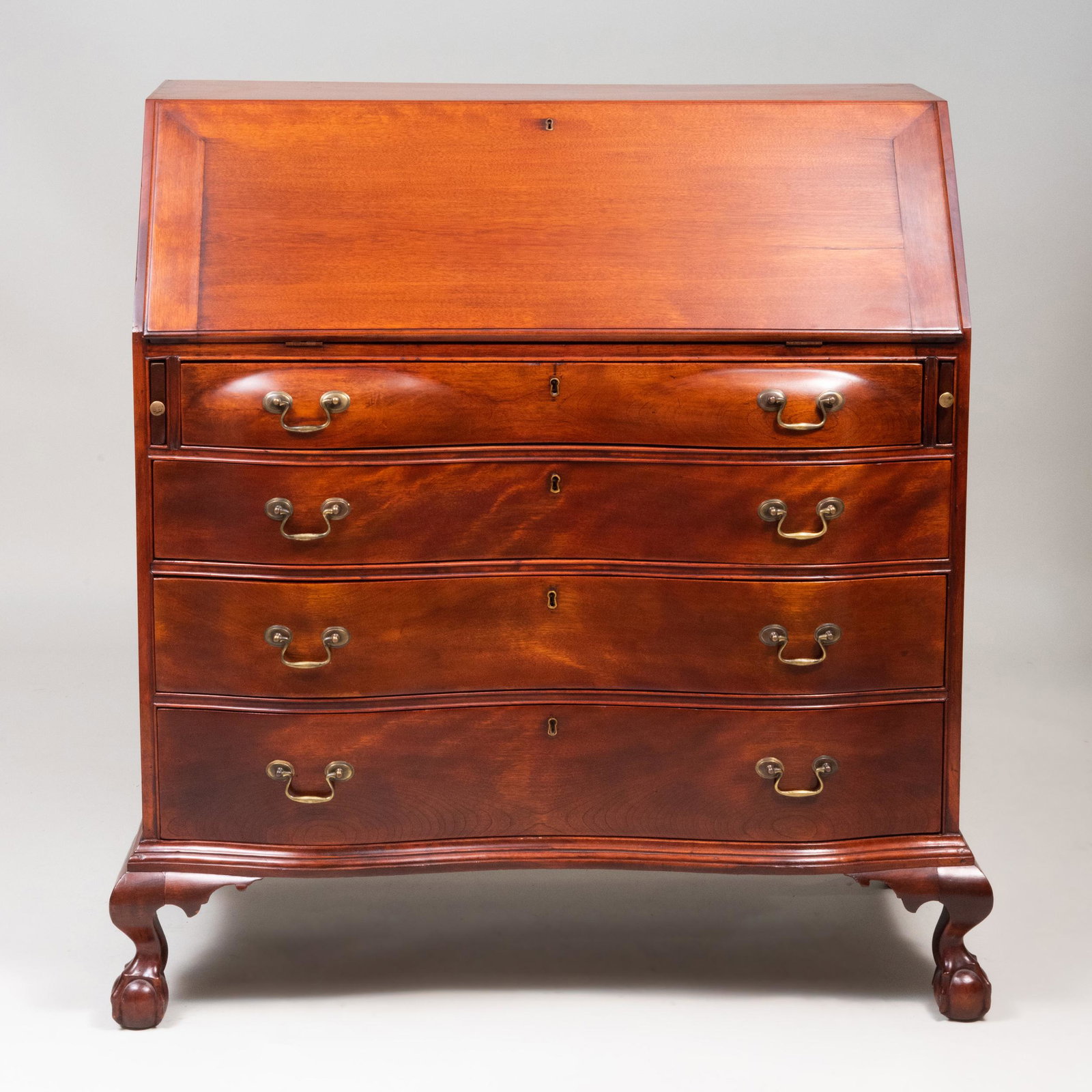 Chippendale Style Mahogany Oxbow Slant-Front Desk,: Chippendale Style Mahogany Oxbow Slant-Front Desk, Massachusetts The slant-front opening to a writing surface and a fitted interior, above four granduating drawers, raised on claw-and-ball feet. 45 1/