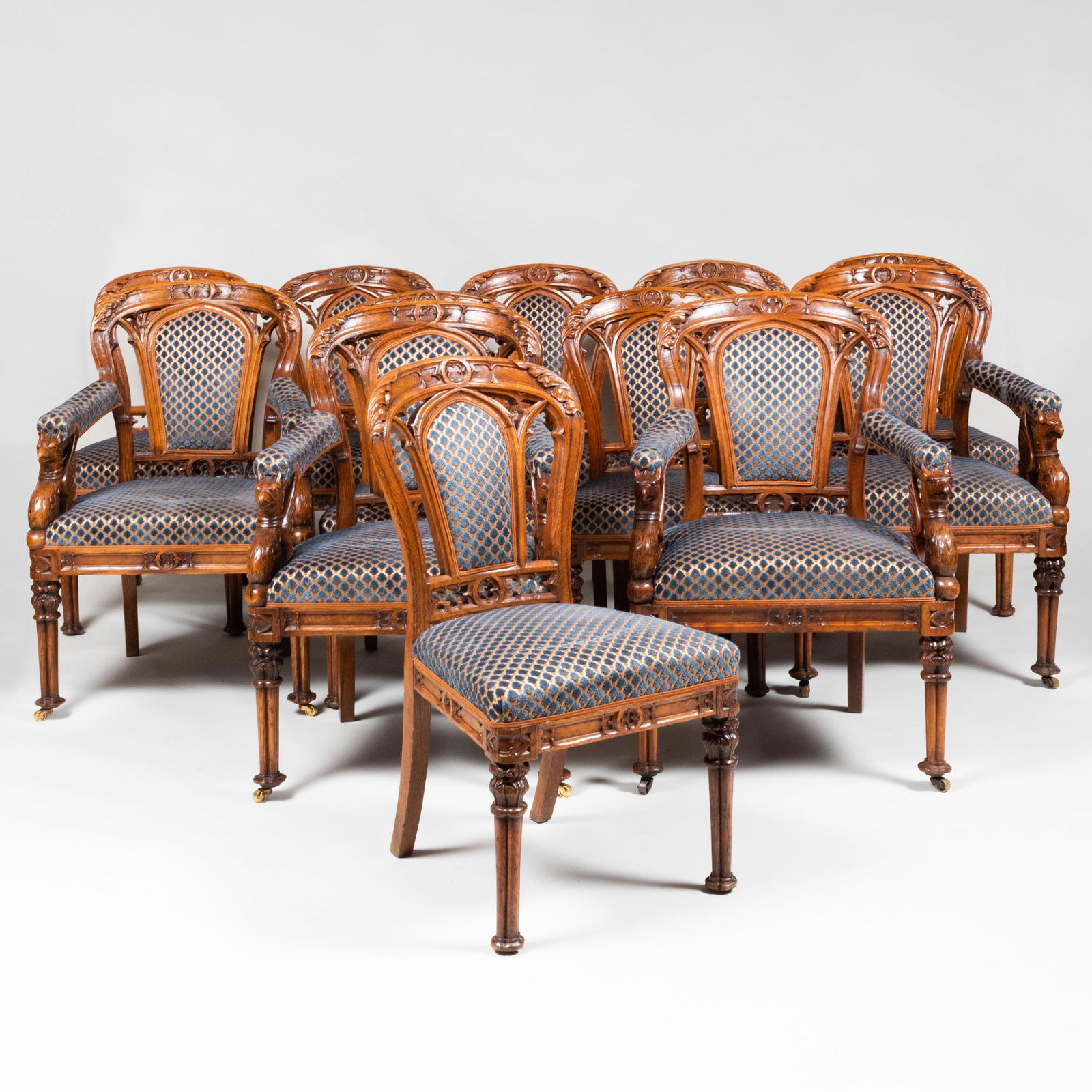 Fine Set of Twelve English Neo-Gothic Carved Oak Dining: Fine Set of Twelve English Neo-Gothic Carved Oak Dining Chairs, in the manner of A.W.N. Pugin Comprising: Four armchairs raised on casters on the front legs. Eight side chairs The largest 36 1/2 x 26