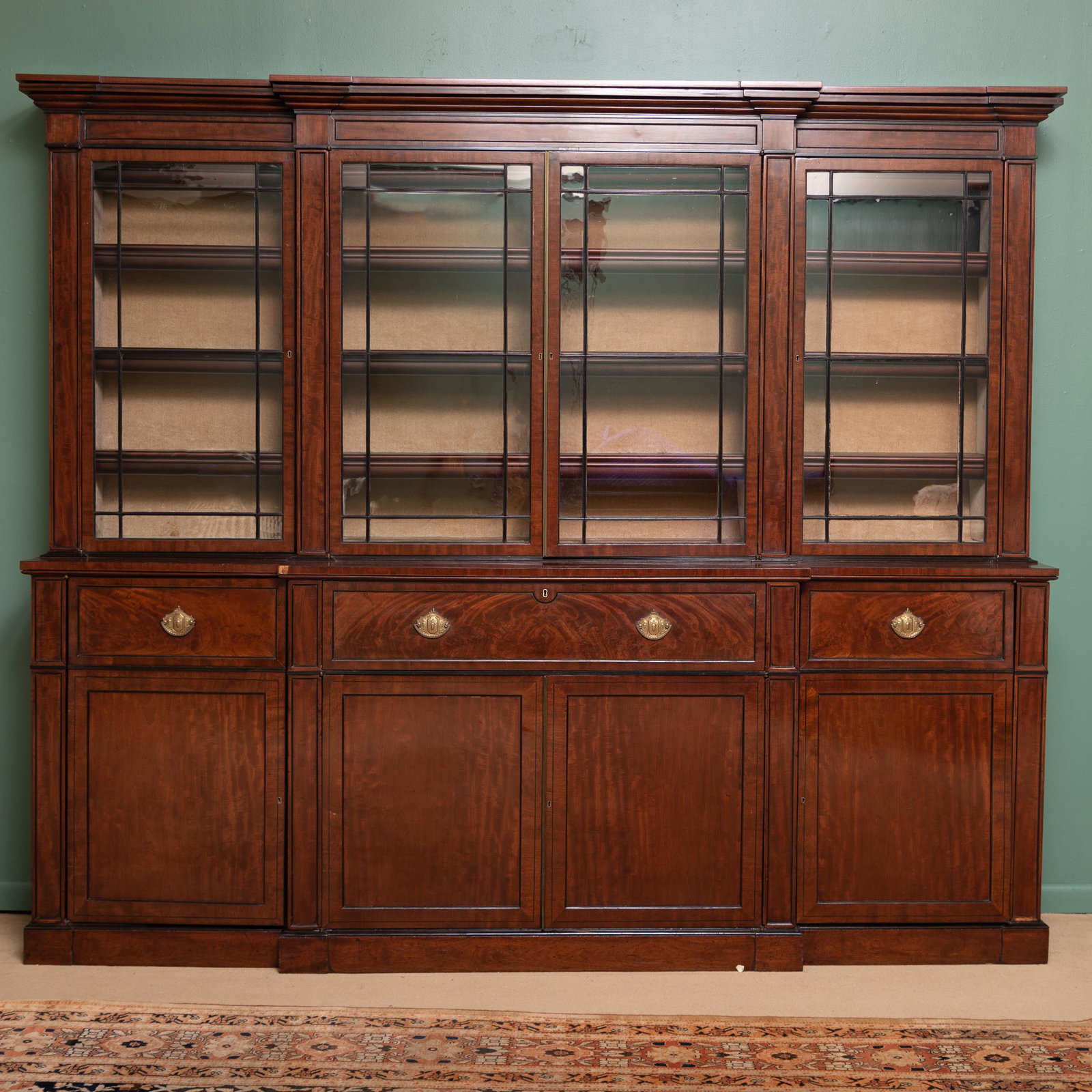 Regency Inlaid Mahogany Breakfront Secretary Bookcase: Regency Inlaid Mahogany Breakfront Secretary Bookcase The overhanging cornice above three sections fitted with three velvet shelves, above the central section with a fall-front drawer opening to a lea