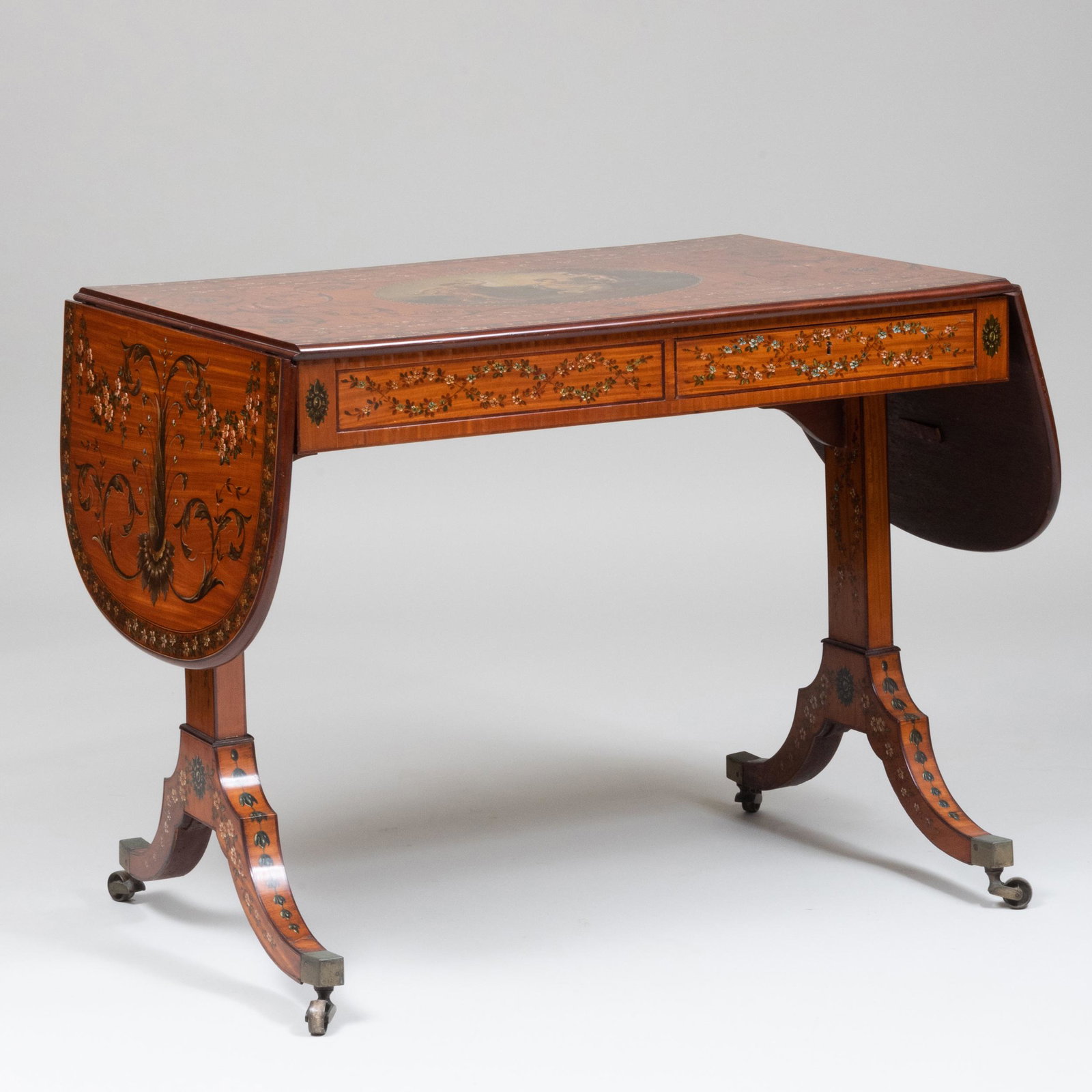 Edwardian Painted Satinwood Sofa Table: Edwardian Painted Satinwood Sofa Table Fitted with two opposing drawers, raised on trestle supports on casters. 29 1/2 x 37 x 24 in. (closed); 29 1/2 x 5 ft. 5 1/4 x 24 in. (open). By repute Drake D