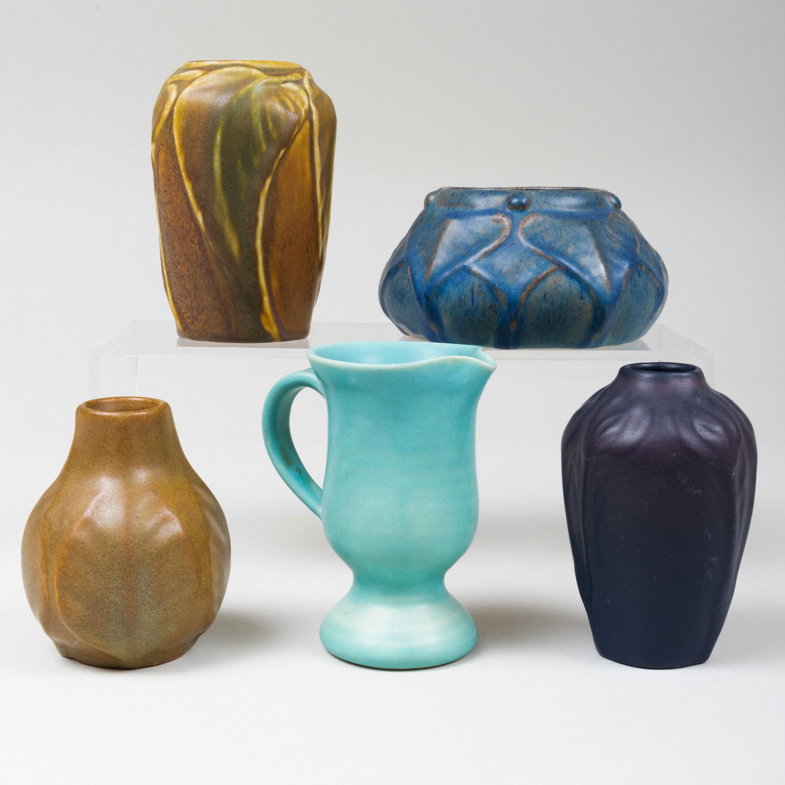 Group of Five Van Briggle Pottery Glazed Vessels: Group of Five Van Briggle Pottery Glazed Vessels Incised marks. Comprising: A blue bud vase molded with flowers A brown bud vase molded with leaves A small brown bottle vase molded with leaves A small