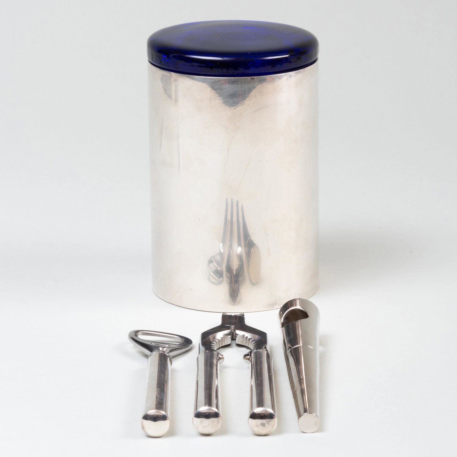 Two Gucci Silver Bar Utensils and a Silvered Metal and: Two Gucci Silver Bar Utensils and a Silvered Metal and Glass Canister The utensils marked '.925'. Comprising: A bottle opener with steel loop and filled handles A cracker with snips with steel cracker