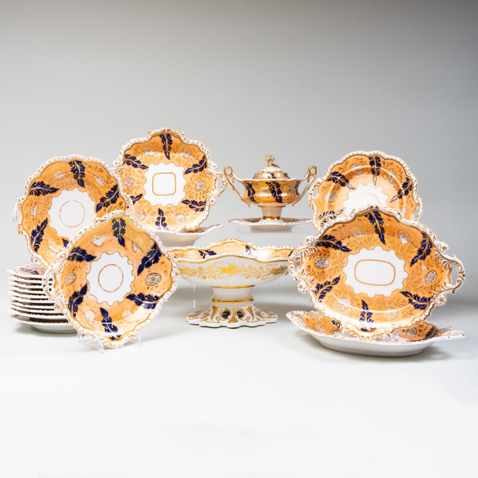 English Peach Ground Porcelain Dessert Service,: English Peach Ground Porcelain Dessert Service, Probably Coalport Iron red '1322'.Comprising:A navette form centerbowlA sauce tureen and cover on fixed standA pair of shaped dishesA pair of square sha