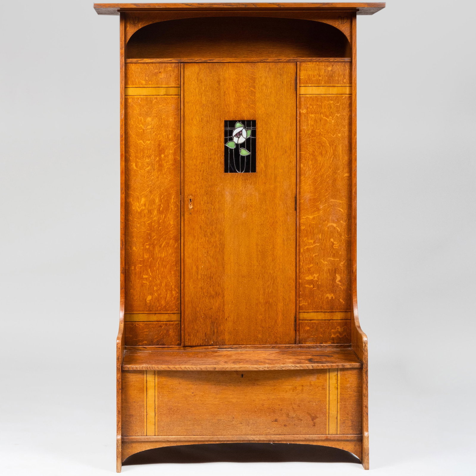 Scottish Arts & Crafts Oak Hall Cupboard with Leaded: Scottish Arts & Crafts Oak Hall Cupboard with Leaded Glass Panel by Earnest Archibald Taylor for Wylie & Lockhead, Glasgow The central door and seat opening to a welled interior. 6 ft. 7 in. x 4 ft. 2