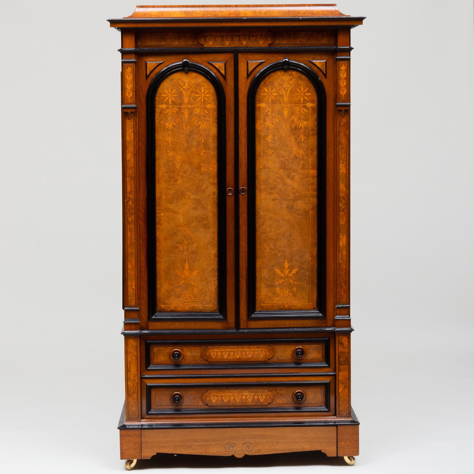 Aesthetic Movement Inlaid Walnut and Ebonized Small: Aesthetic Movement Inlaid Walnut and Ebonized Small Armoire, attributed to Herter Brothers The overhanging cornice above a pair of cabinet doors, above two inlaid drawers and a base drawer, raised on 