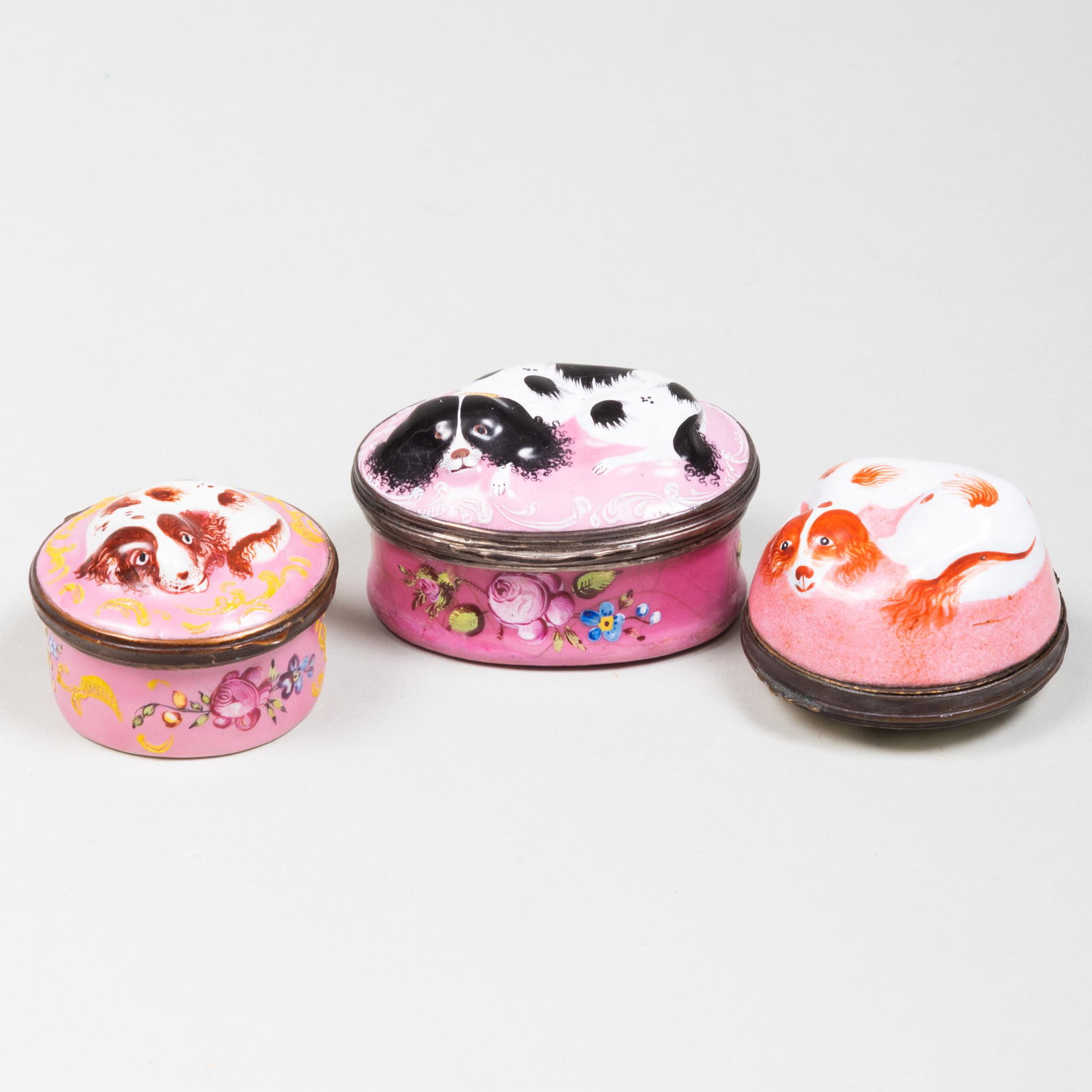 Group of Three Staffordshire Enamel King Charles: Group of Three Staffordshire Enamel King Charles Spaniel Boxes Comprising: An oval box with a black and white spaniel A circular box with a brown and white spaniel and interior mirror A circular box w