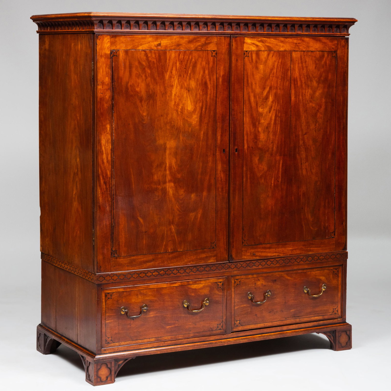 Fine George III Inlaid Satinwood and Ebony Linen Press,: Fine George III Inlaid Satinwood and Ebony Linen Press, in the Neo-Gothic Taste The pair of doors opening to a welled interior above two short drawers, raised on quatrefoil carved block feet. Inlaid w