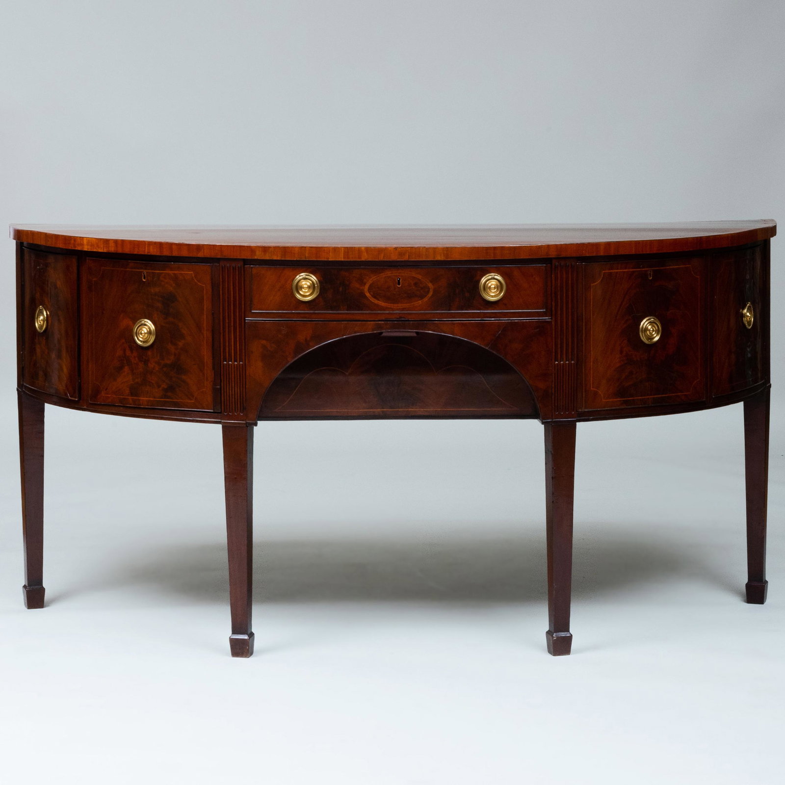 George III Inlaid Mahogany D-Shaped Sideboard: George III Inlaid Mahogany D-Shaped Sideboard Fitted with a central drawer flanked by a bottle drawer on the right and a deep drawer on the left, flanked by corner doors, above the baise-lined butler'