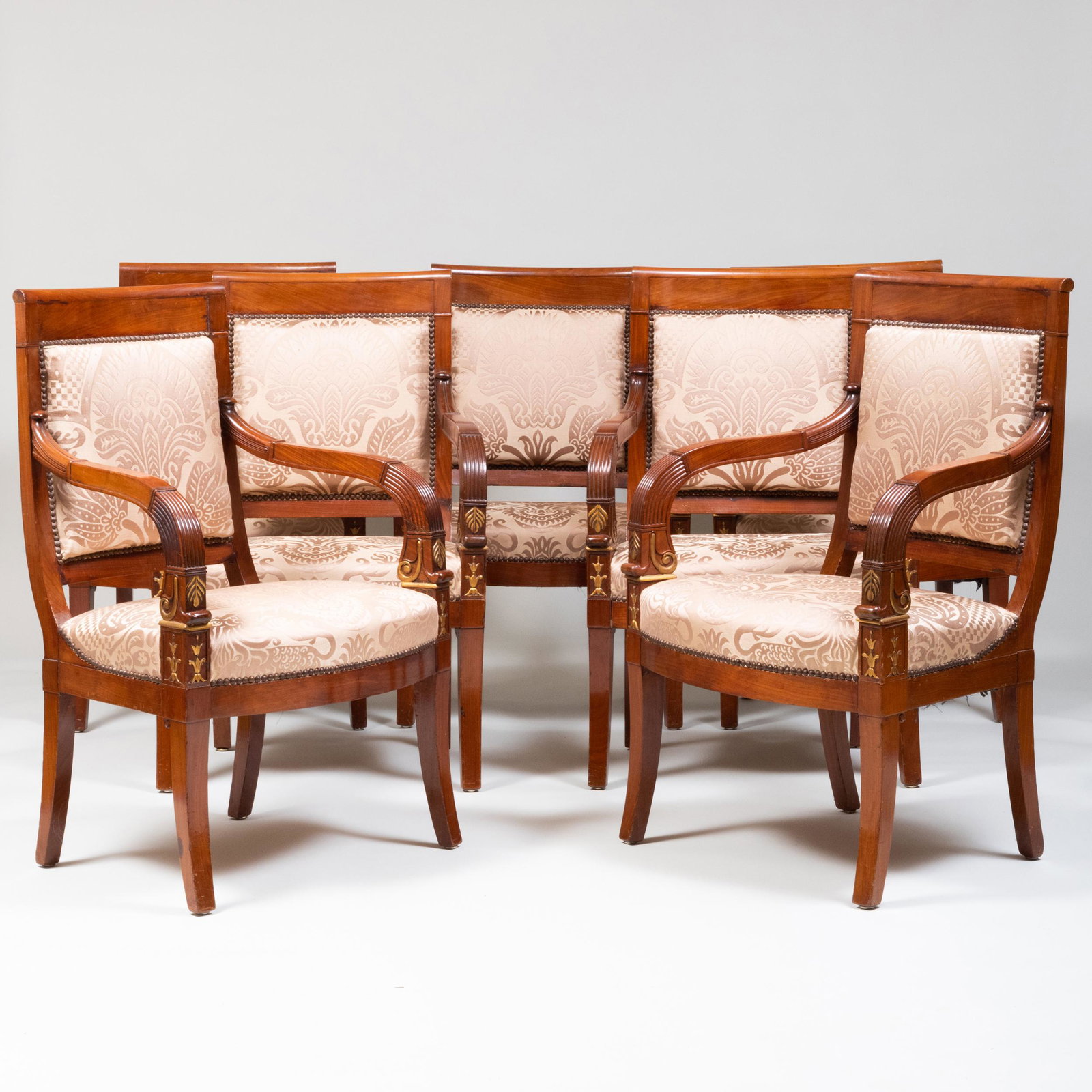 Set of Seven Empire Mahogany and Parcel-Gilt Fauteuils en Cabriolet: Set of Seven Empire Mahogany and Parcel-Gilt Fauteuils en Cabriolet With a Sotheby's NY label sale 8879, lot 423. Upholstered in silk damask fabric. 36 1/2 x 23 1/2 x 17 3/4 in., height of seat 