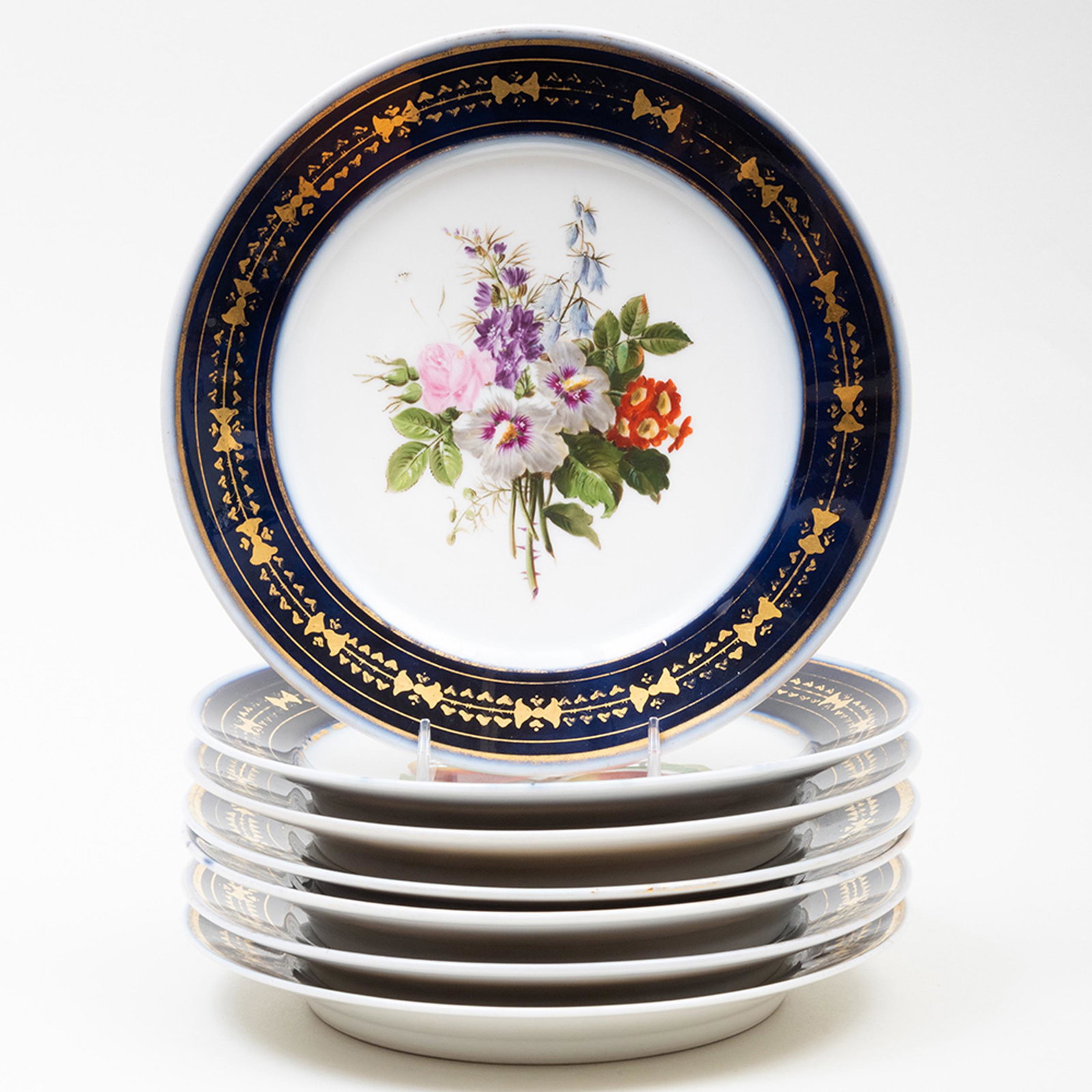 Set of Seven Nyon Porcelain Dessert Plates: Set of Seven Nyon Porcelain Dessert Plates Most with black printed marks, six decorated with flowers, one with fruit. 8 1/2 in. diam.