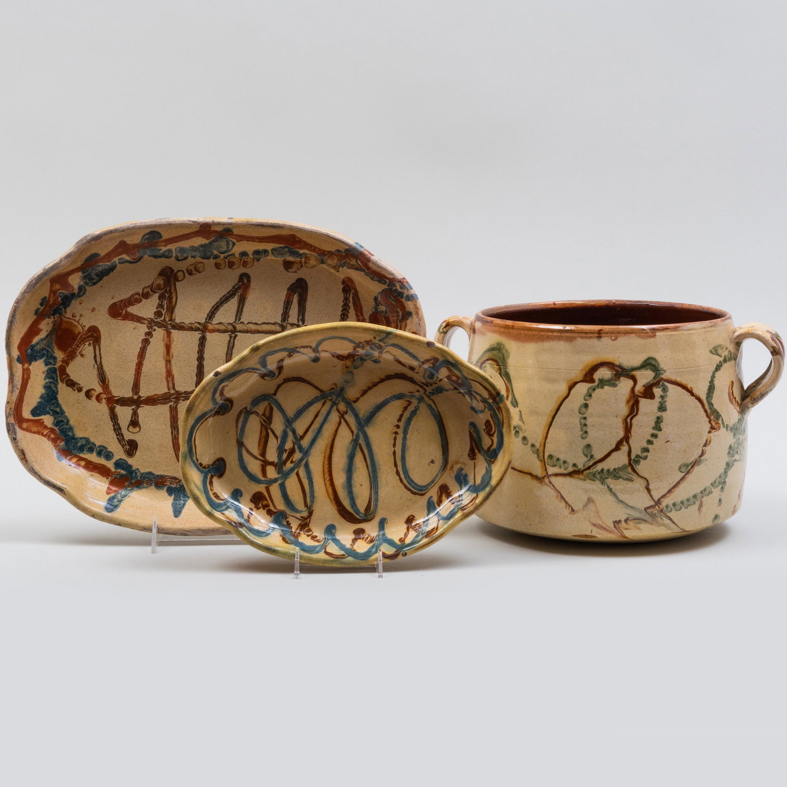 Group of Three Slip Decorated Vessels: Group of Three Slip Decorated Vessels Impressed marks. Comprising: A two handle crock A large oval dish A small oval dish The crock 8 x 12 x 9 1/2 in. Property from the Collection of Carol Horn