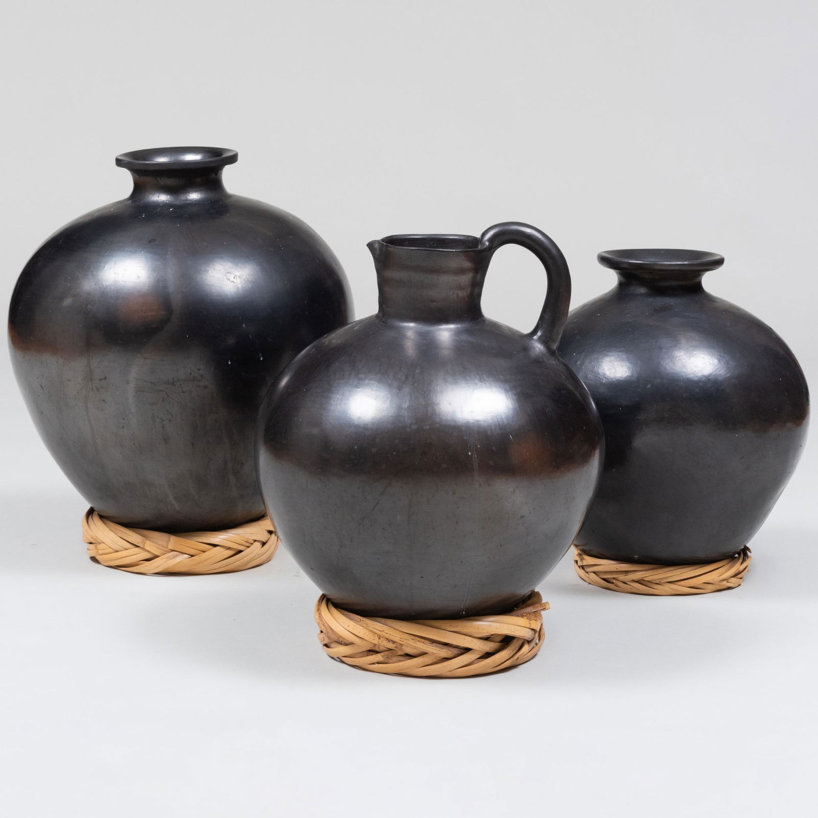 Group of Three Black Burnished Earthenware Pottery Vessels, Possibly Moroccan: Group of Three Black Burnished Earthenware Pottery Vessels, Possibly Moroccan Together with three woven rattan support rings. The largest 21 x 16 in. diam. Property from a Private New York Collection