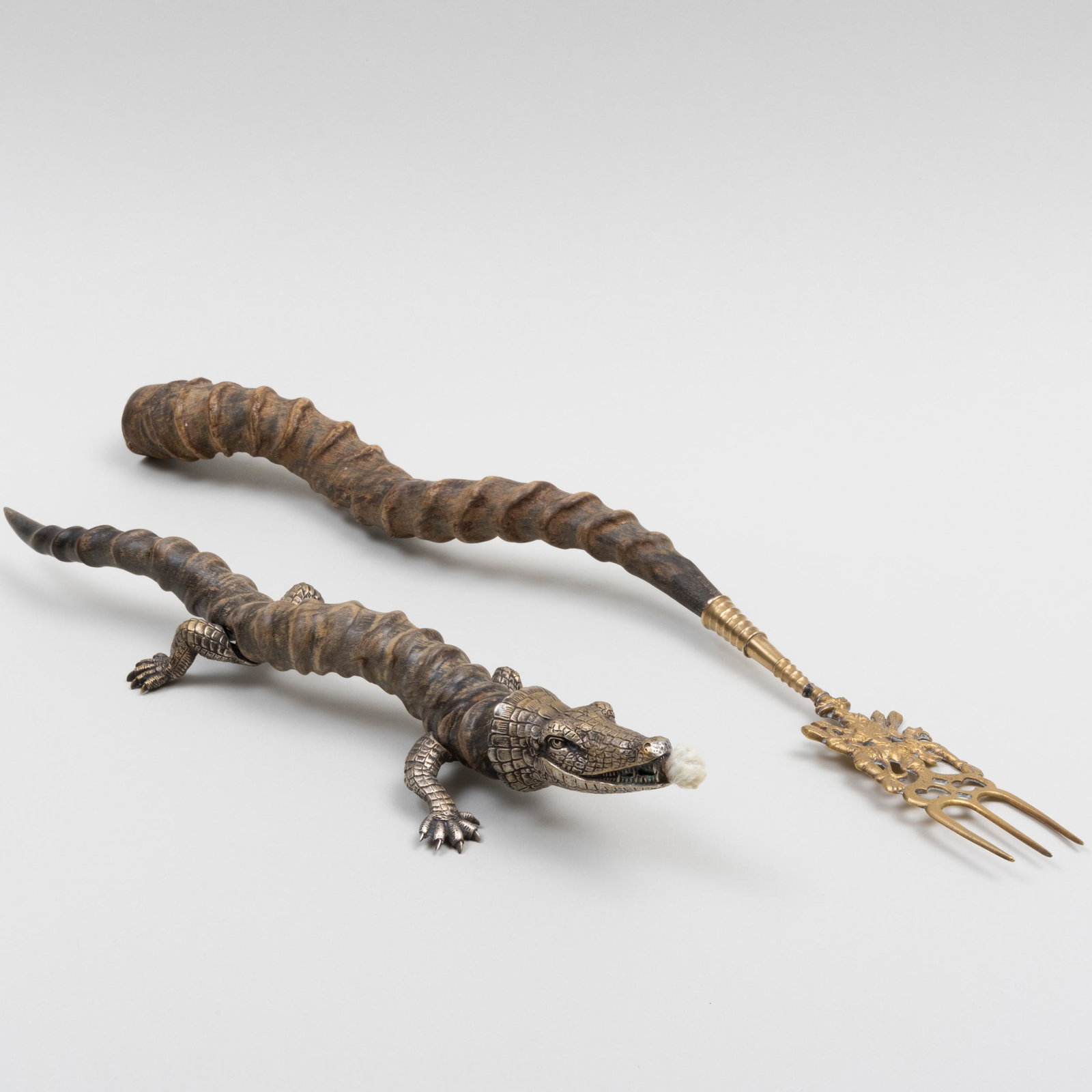 Two Metal-Mounted Horn Table Articles: Two Metal-Mounted Horn Table Articles Comprising:A crocodile cigar lighterA toasting forkThe larger 16 in. long. Property of a Gentleman, Salisbury, CT