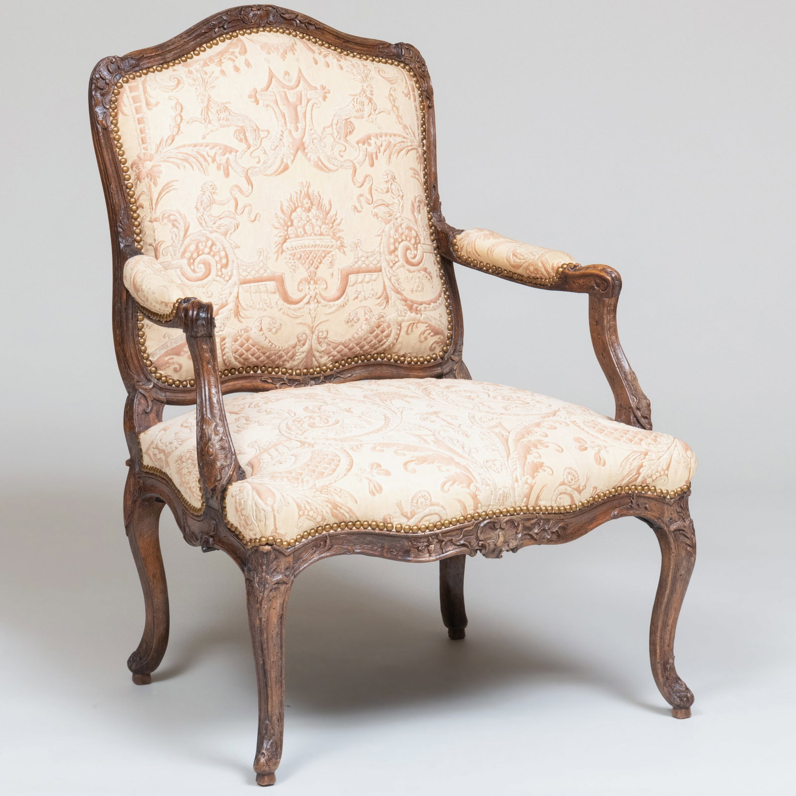 Early Louis XV Carved Beechwood Fauteuil à la Reine: Early Louis XV Carved Beechwood Fauteuil ? la Reine Upholstered in Fortuny fabric with hand stitching couching to hold areas in relief.40 1/4 x 29 x 24 in. seat height 17 in.