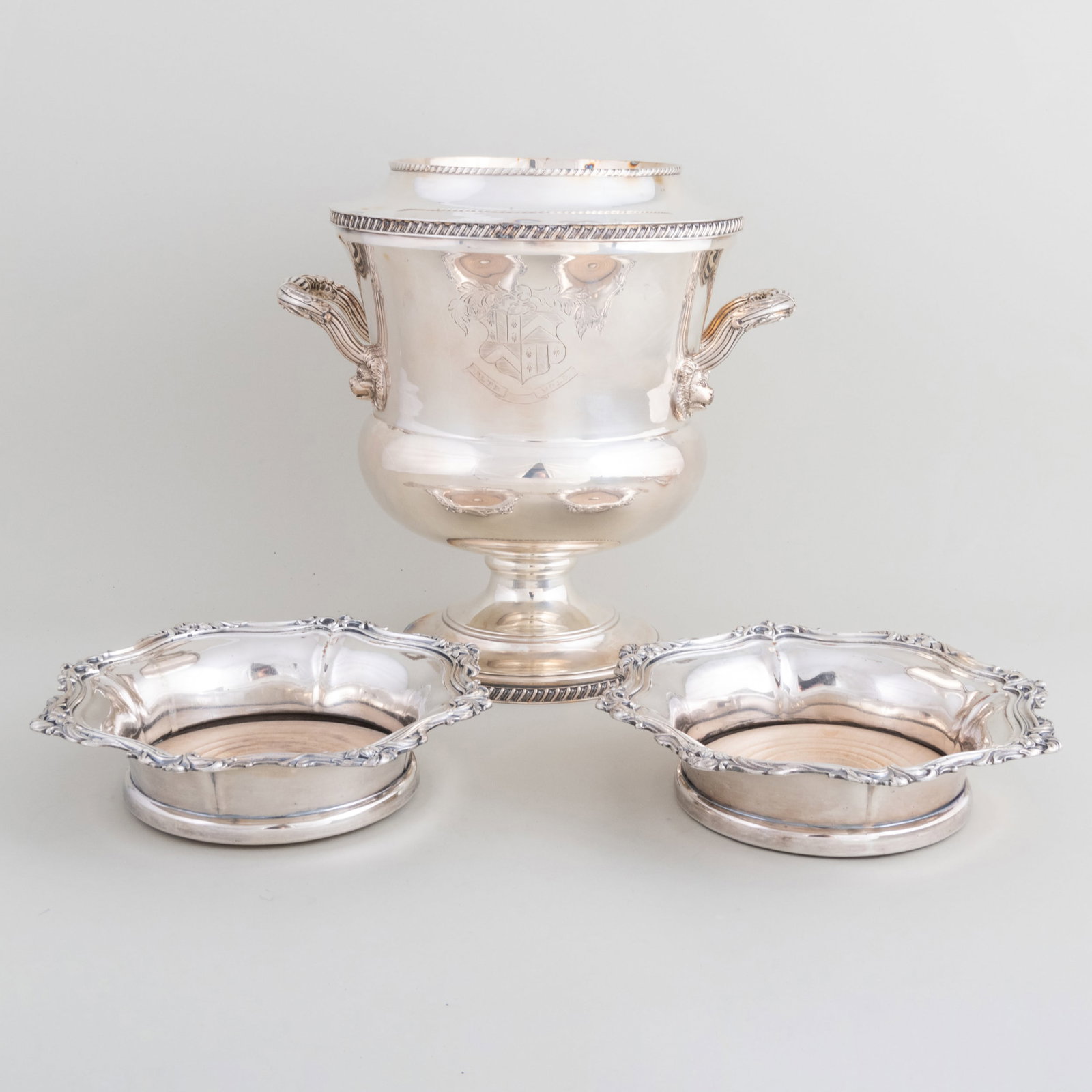 English Silver Plate Wine Cooler and a Pair of Bottle Coasters: English Silver Plate Wine Cooler and a Pair of Bottle Coasters The cooler engraved with armorial. The cooler 10 1/4 x 9 1/4 x 8 in., the coasters 1 7/8 x 8 in. diam. The Estate of Jacqueline Leed